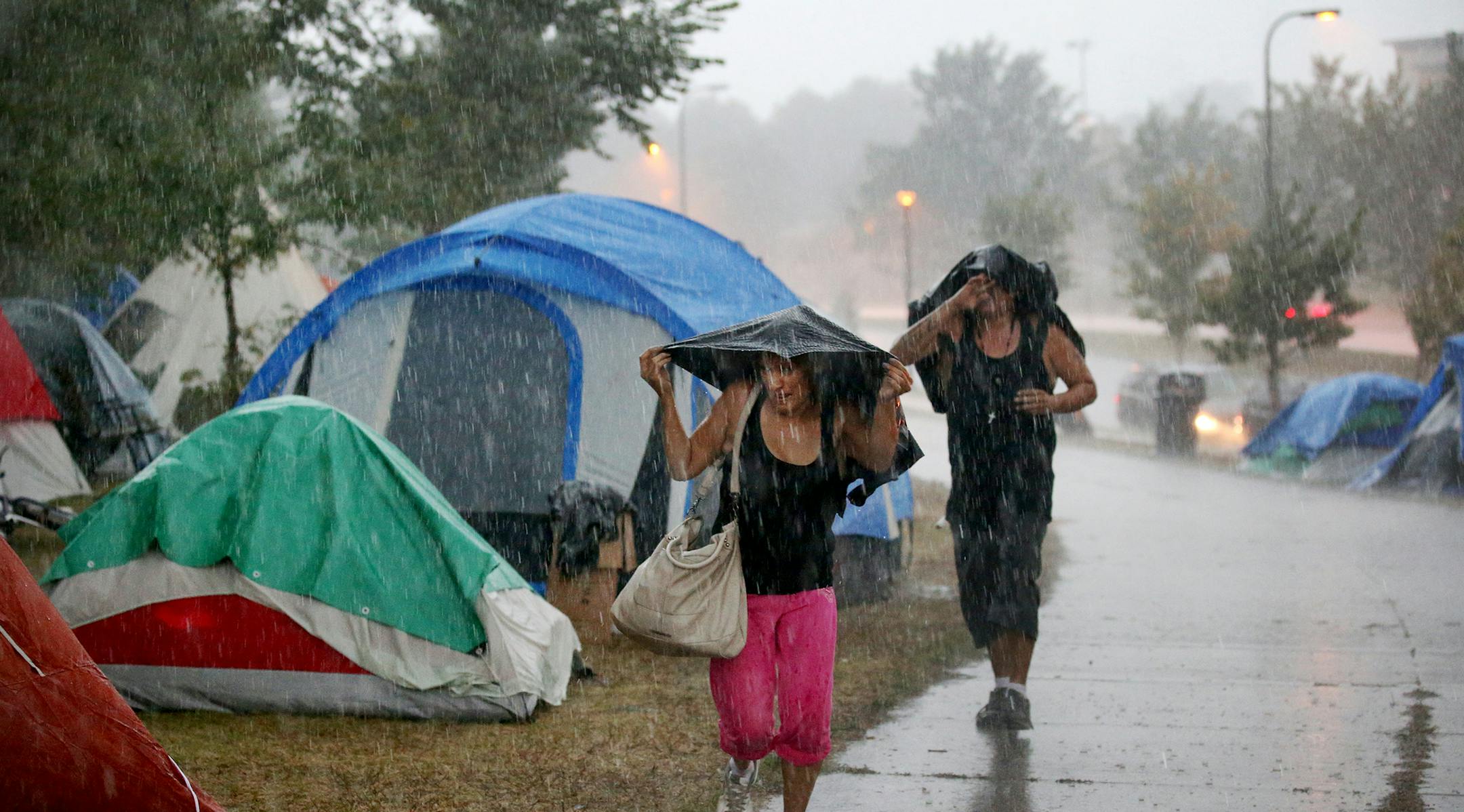 An American Indian encampment in south Minneapolis continues to grow and now includes several families with children. Some have come hoping to receive services that might end their homelessness. Here, people living in the camp run for cover as the skies open with heavy rain Monday, Aug. 27, 2018, in Minneapolis, MN.] DAVID JOLES ï david.joles@startribune.com Homeless families at the American Indian encampment in south Minneapolis**Koda Deer,cq