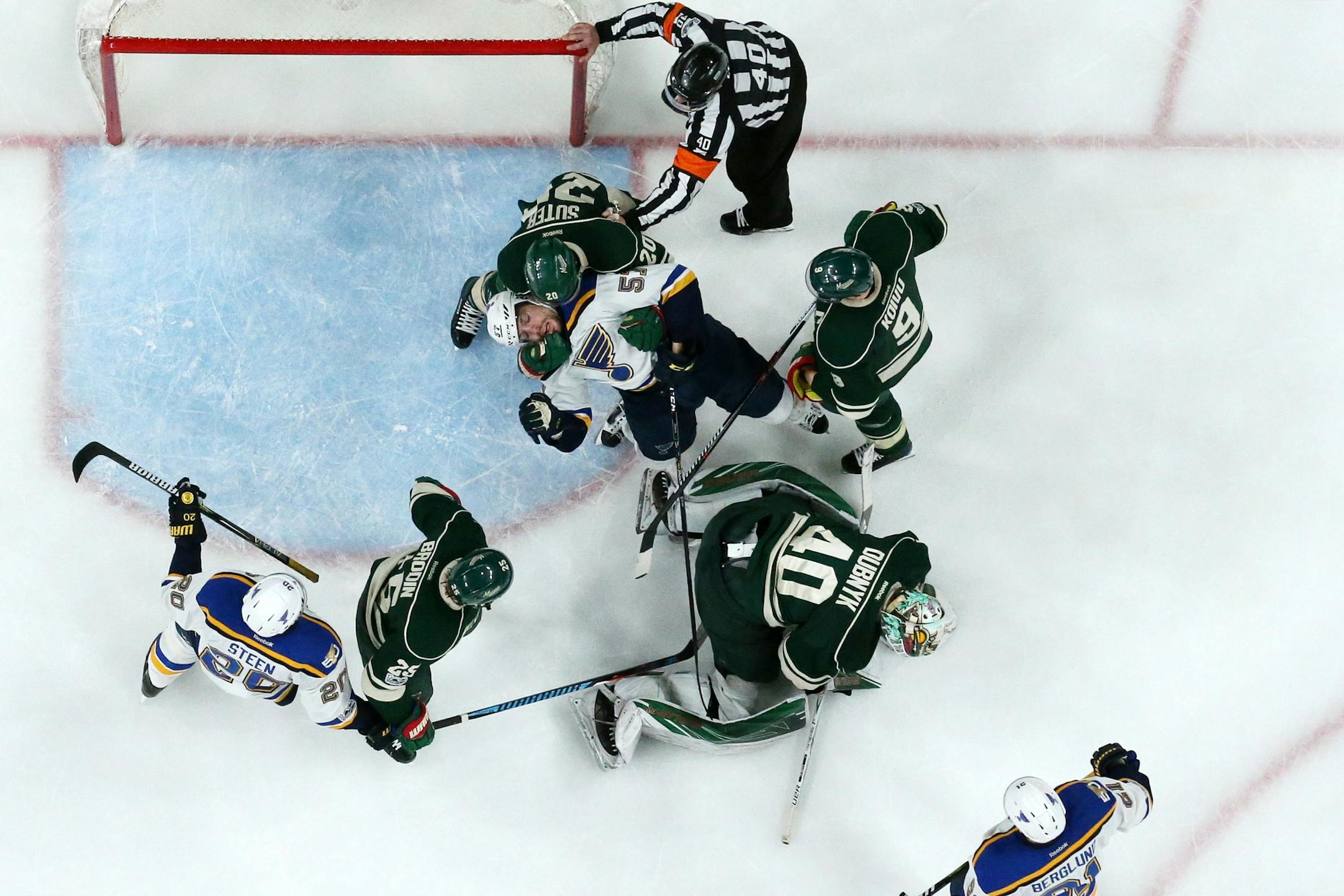 St. Louis Blues left wing David Perron (57) got pulled down by Minnesota Wild defenseman Ryan Suter (20) as Minnesota Wild goalie Devan Dubnyk (40) made a save in the third period.