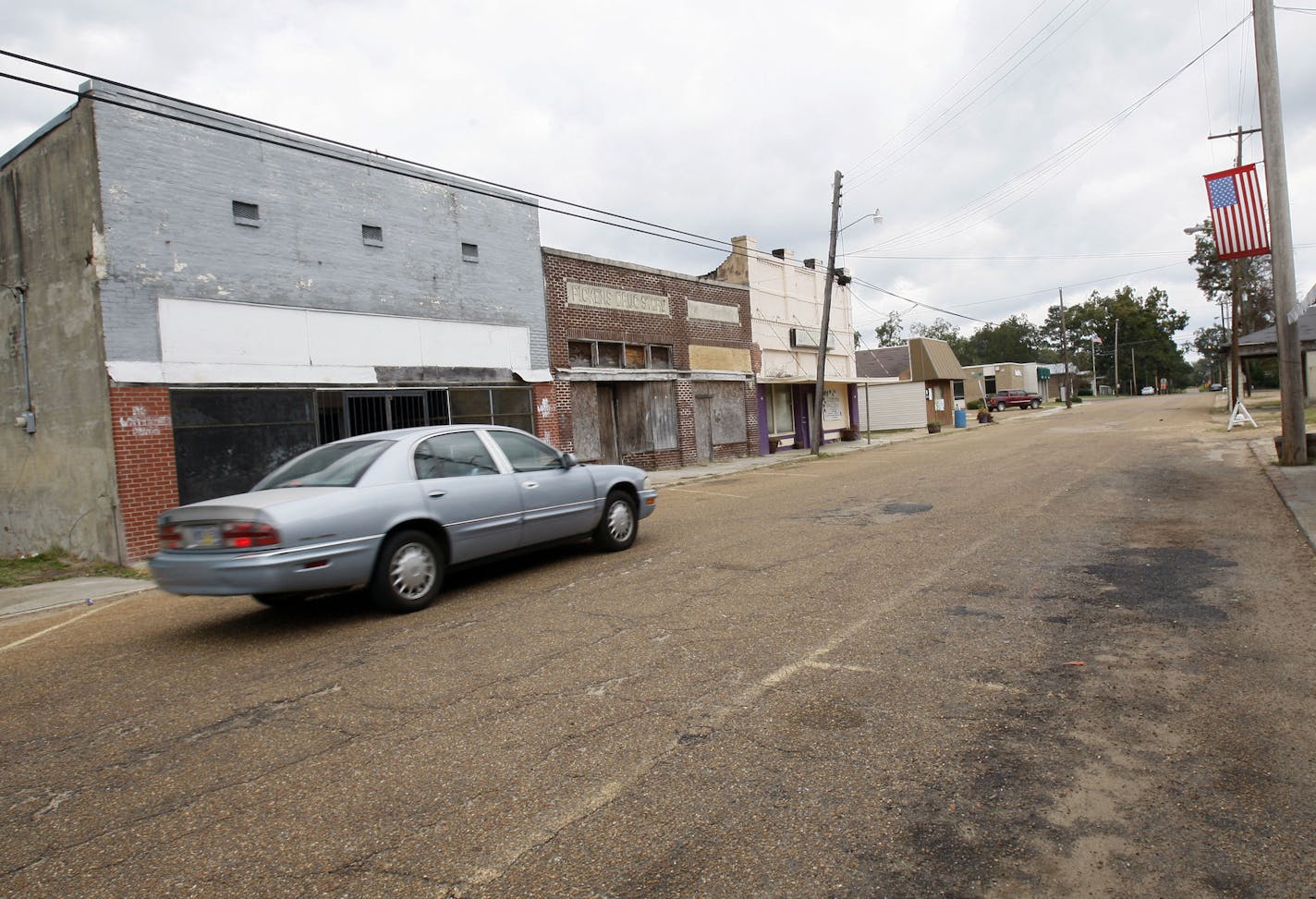 In this Oct 19, 2011 photograph, an automobile rolls past many closed storefront businesses in downtown Pickens, Miss. Voters in this Delta community believe the incoming governor must develop a plan to address the poverty of Holmes County and the joblessness in the Delta. (AP Photo/Rogelio V. Solis) ORG XMIT: MSRS103