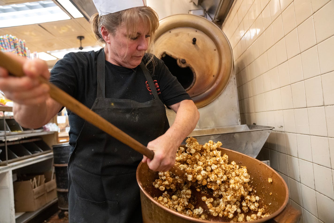 Brenda Lamb, owner of Candyland, mixes a fresh batch of caramel popcorn.