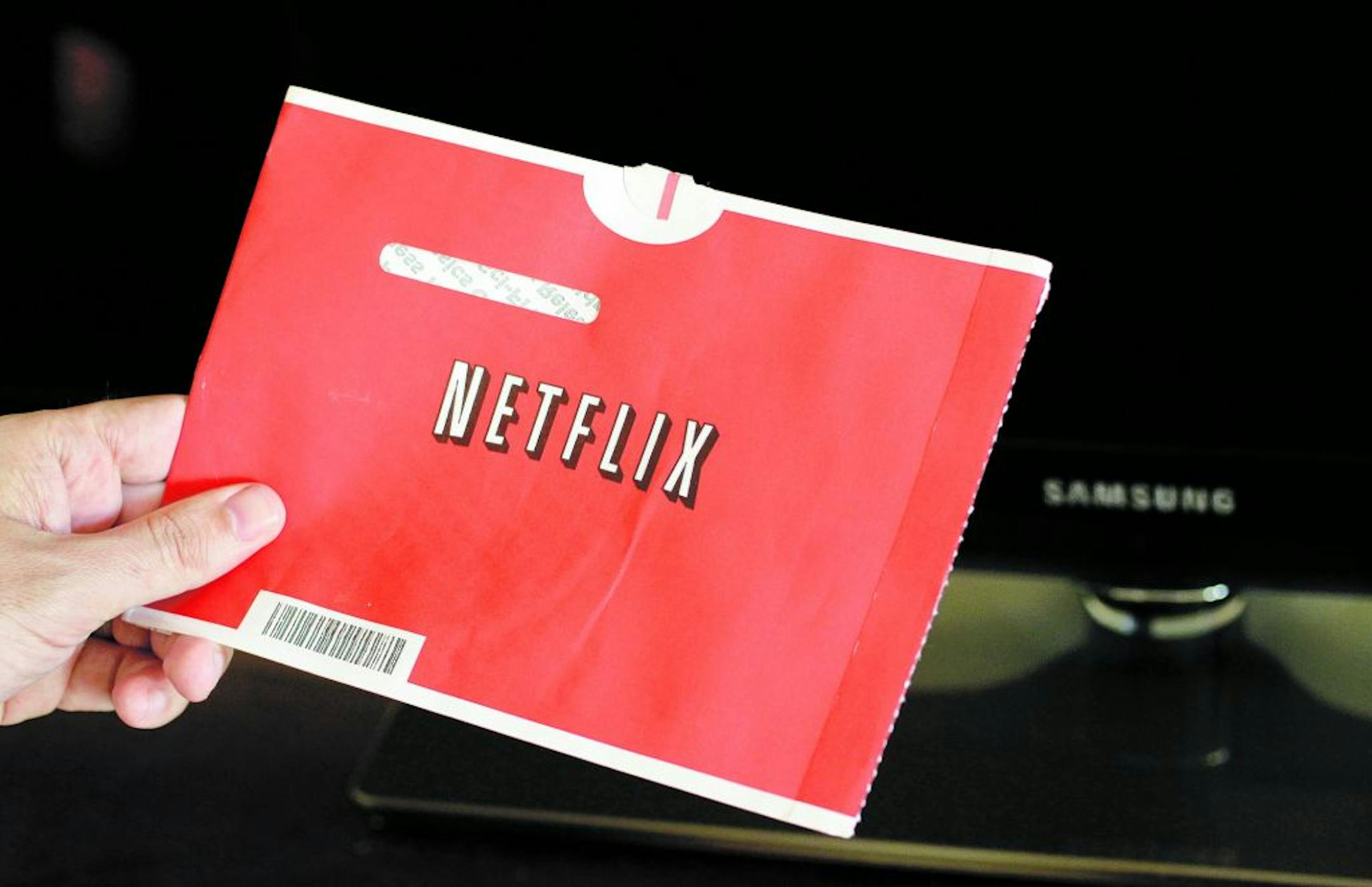 This photo made Tuesday, July 20, 2010, a Netflix customer holds up a movie in Palo Alto, Calif. Netflix Inc.'s second-quarter performance got panned by investors Wednesday for bringing in less revenue than expected, even though the movie subscription service added a million more customers to produce another earnings extravaganza.