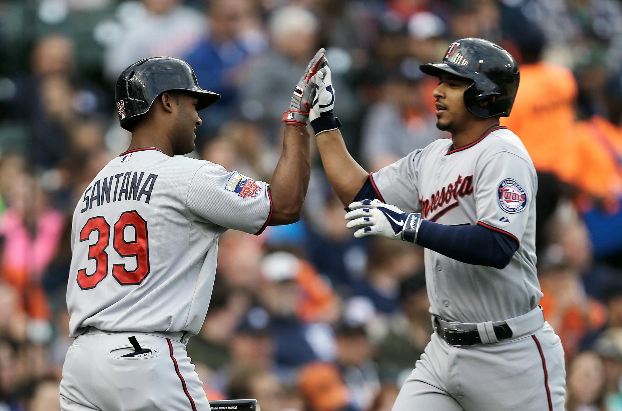 Minnesota Twins' Eduardo Escobar, right, is congratulated by Danny Santana after hitting a solo home run against the Detroit Tigers in the third inning of a baseball game in Detroit, Friday, June 13, 2014. (AP Photo/Paul Sancya)