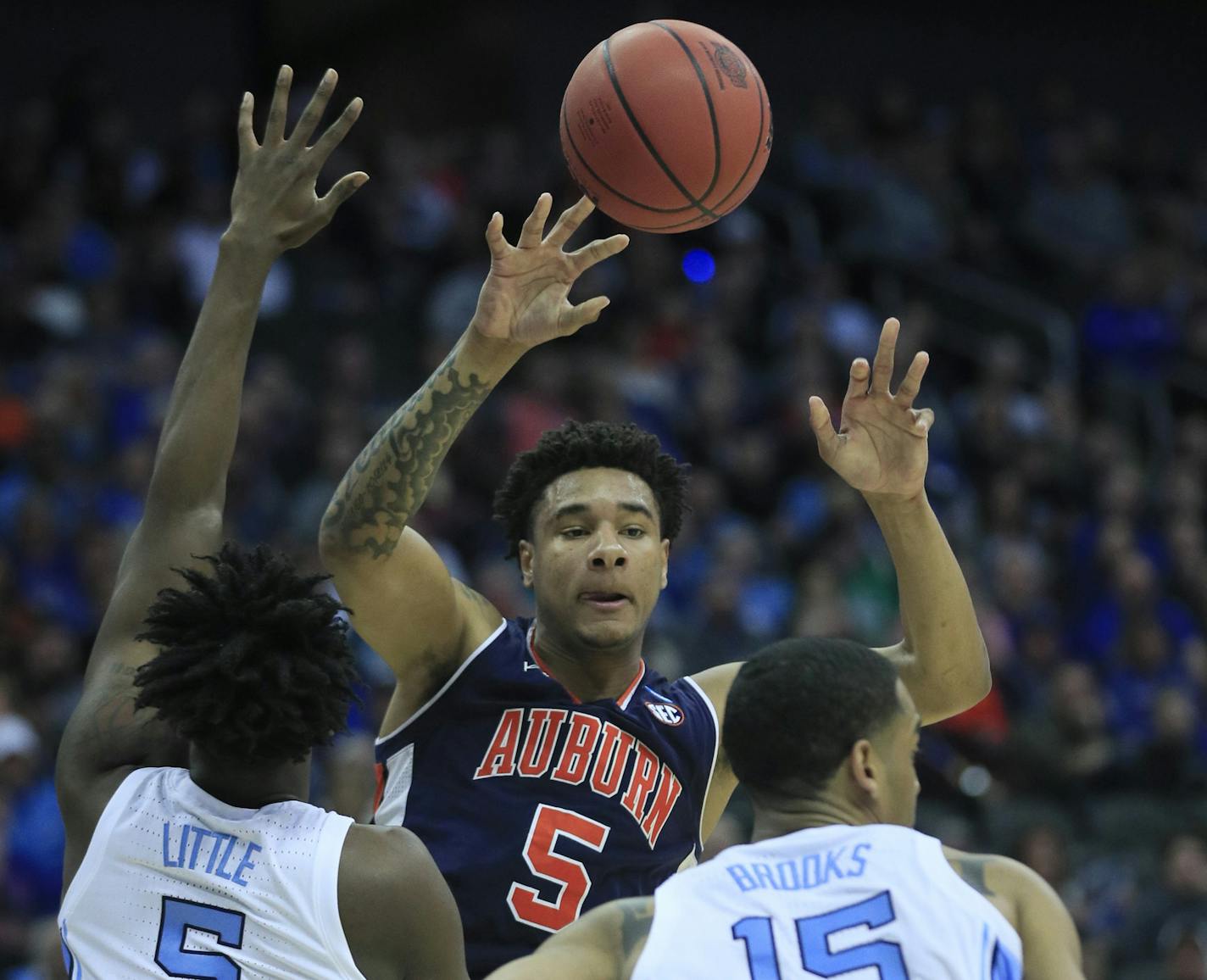 Auburn's Chuma Okeke (5) passes over North Carolina's Nassir Little (5) and Garrison Brooks during the first half of a men's NCAA tournament college basketball Midwest Regional semifinal game Friday, March 29, 2019, in Kansas City, Mo. (AP Photo/Orlin Wagner)