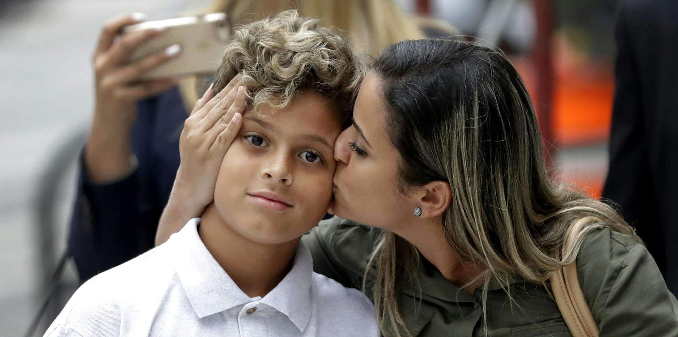 FILE - In this July 5, 2018 file photo, Sirley Silveira Paixao, an immigrant from Brazil seeking asylum, kisses her 10-years-old son Diego Magalhaes, after Diego was released from immigration detention in Chicago. A Justice Department filing hours before a hearing Friday, July 6 in San Diego says the administration needs more time to reunite all children with their parents by July 26 - and July 10 for children under 5. It says federal law requires it to complete reviews to ensure that the child