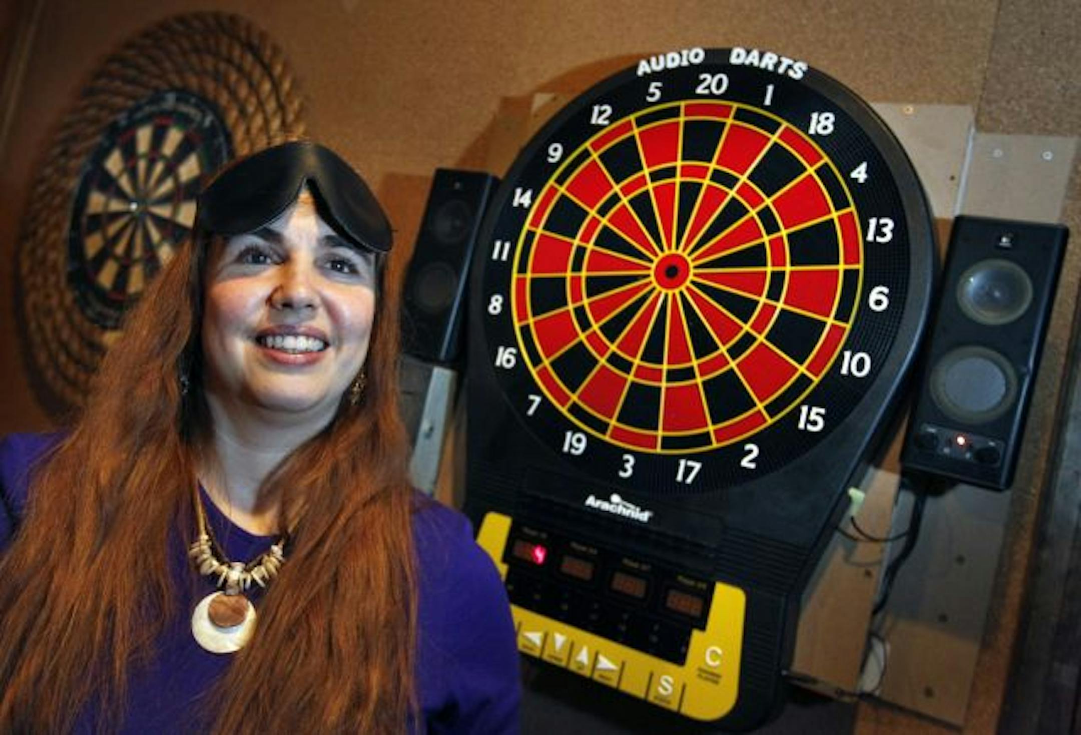 Sam Jasmine, president of the Twin Cities Audio Darts League, loves the game so much that she designed the "talking" dartboard hanging in Merlin's Rest.