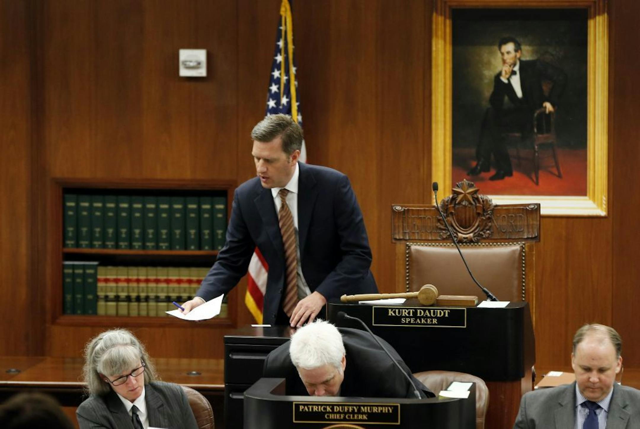 A smaller portrait of Abe Lincoln hangs behind House Speaker Kurt Daudt, center, in a hearing room where Minnesota House members met for a special session of the Minnesota Legislature, Friday, June 12, 2015, in St. Paul, Minn. The State Capitol is under renovation, requiring the move to the temporary meeting rooms in the State Office Building.