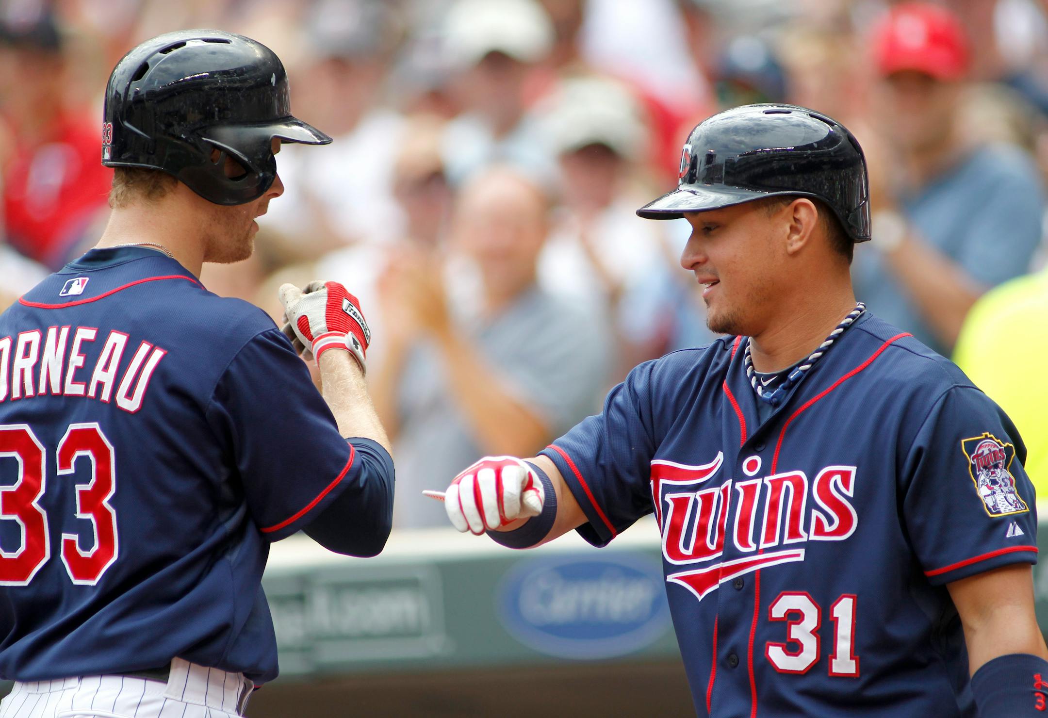 The Twins' Justin Morneau was congratulated by Oswaldo Arcia after hitting a two-run homer in the first inning against Houston on Sunday. Arcia's seventh-inning solo shot supplied the go-ahead run in the Twins' 3-2 victory.
