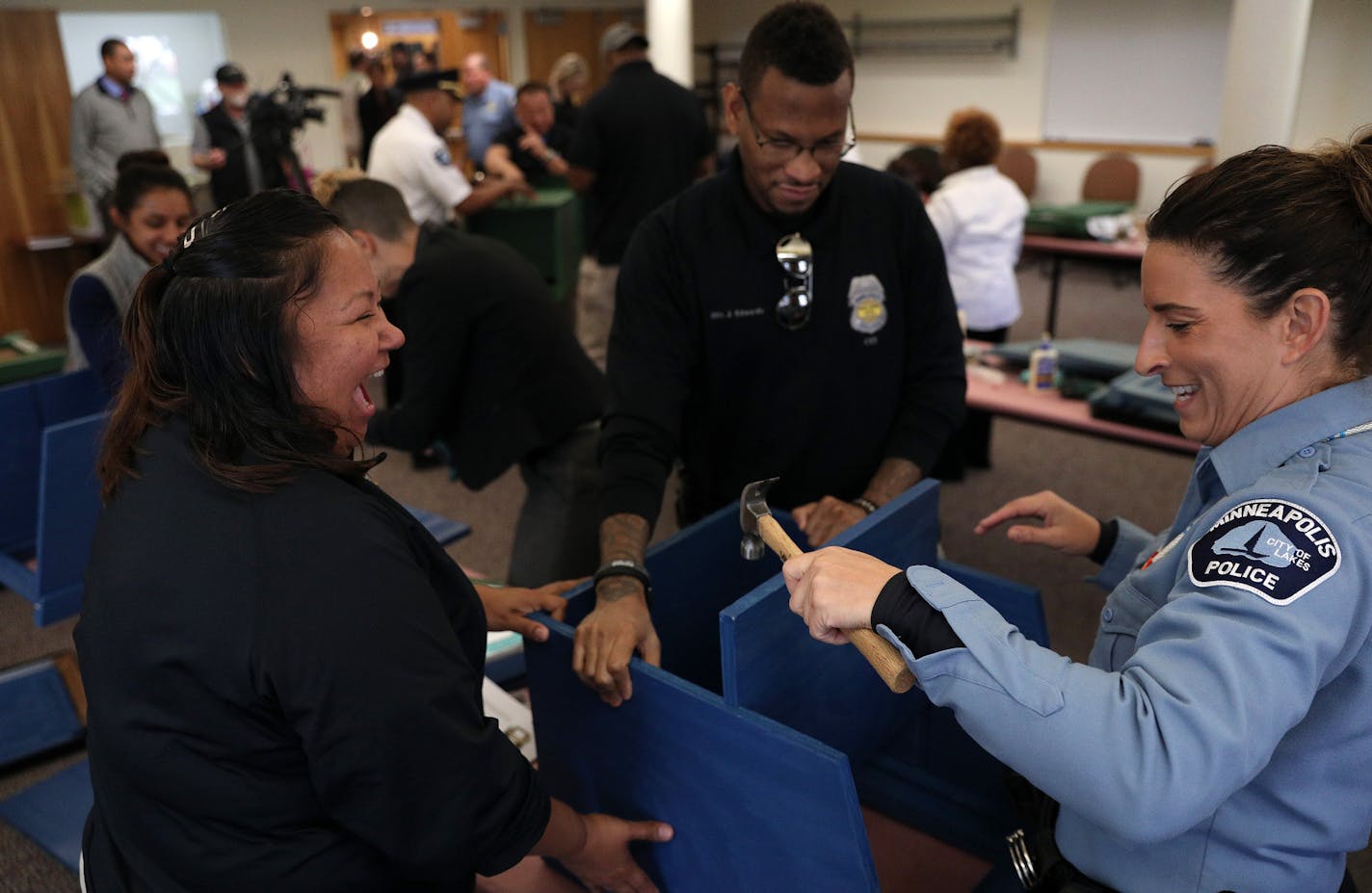 Police officers Colleen Saunby, right, Cheryl Goodman, left, and Jon Edwards, center, worked to build free-standing Little Free Libraries Tuesday. ] ANTHONY SOUFFLE &#xef; anthony.souffle@startribune.com Police Chief Medaria Arradondo and a handful CET officers spent a few hours building free-standing little free libraries that can be seen around the city at the station Tuesday, Oct. 17, 2017 at the Fourth Precinct in Minneapolis. The Minneapolis Police Department is launching what officials hav