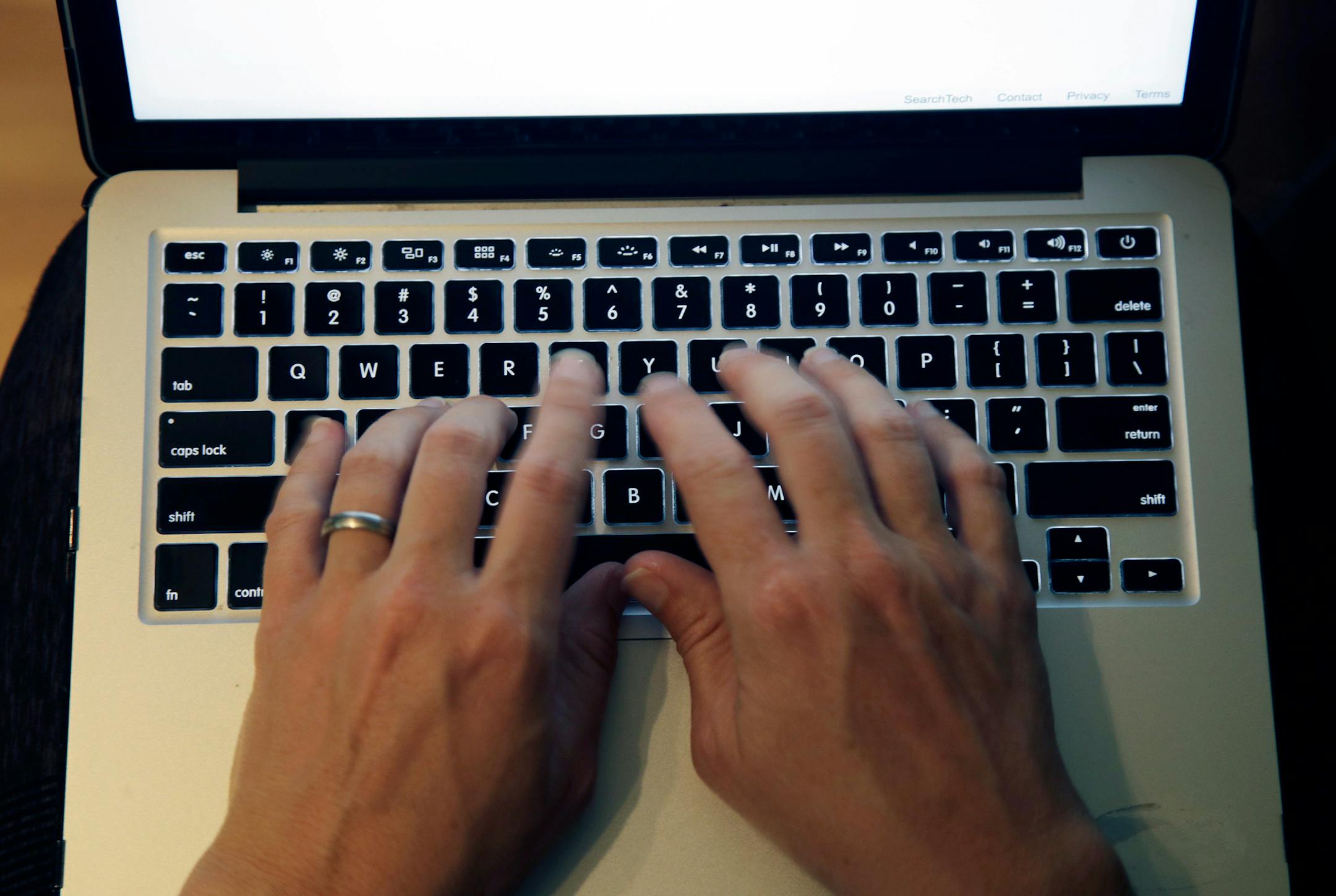 FILE - This June 19, 2017, file photo shows fingers on laptop keyboard in North Andover, Mass. Americans appear to be heeding expert advice for keeping their passwords and accounts safe. A new poll by The Associated Press and the NORC Center for Public Affairs Research finds that 41 percent of Americans use unique passwords for most or all online services. (AP Photo/Elise Amendola, File) ORG XMIT: NYHK202