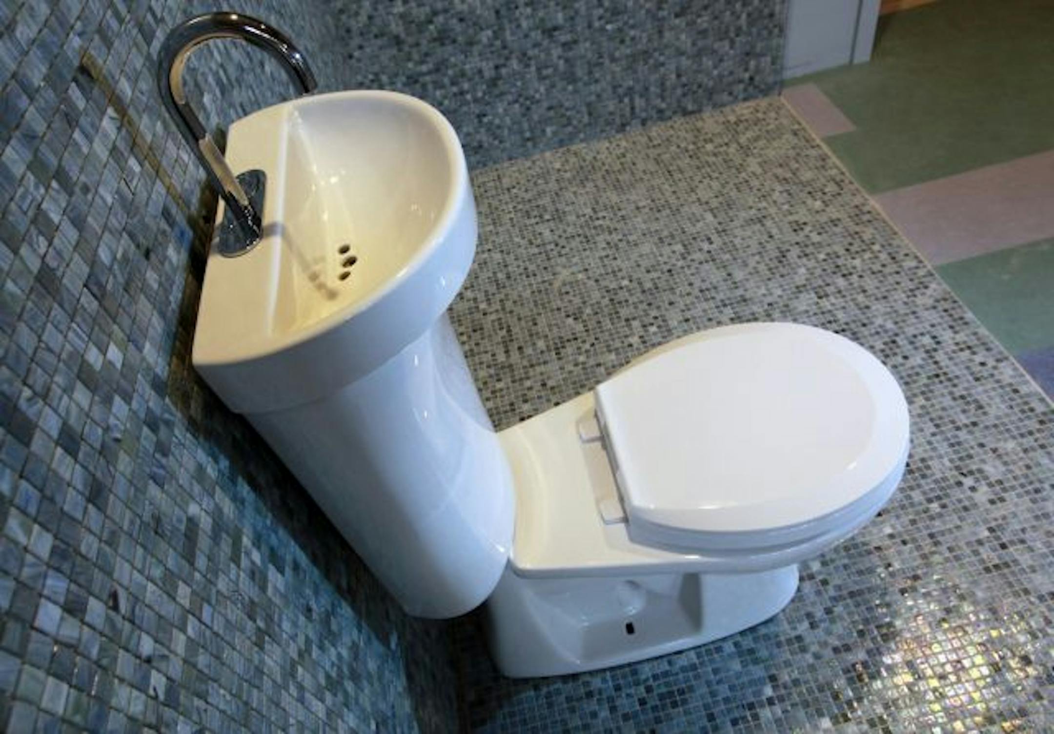 The toilet with a sink on top saves water by using it twice; once to wash hands, then to flush.