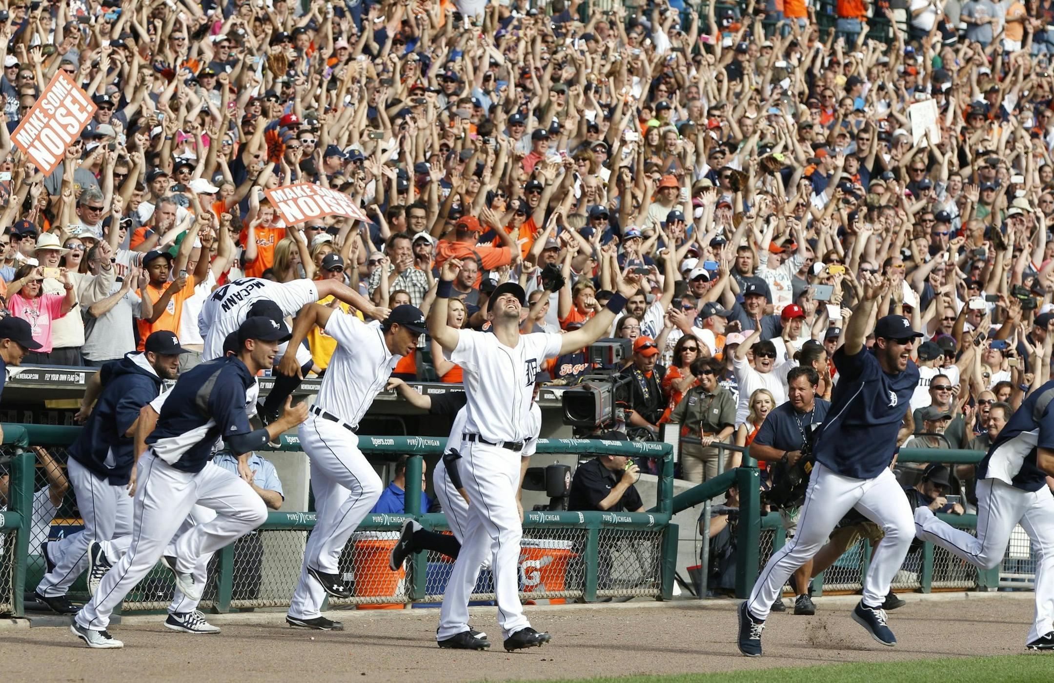 Detroit Tigers players run out of the dugout to joint the on-field celebration after their win over the Minnesota Twins clinched the American League Central Division on Sunday, Sept. 28, 2014, at Comerica Park in Detroit. (Julian H. Gonzalez/Detroit Free Press/MCT)
