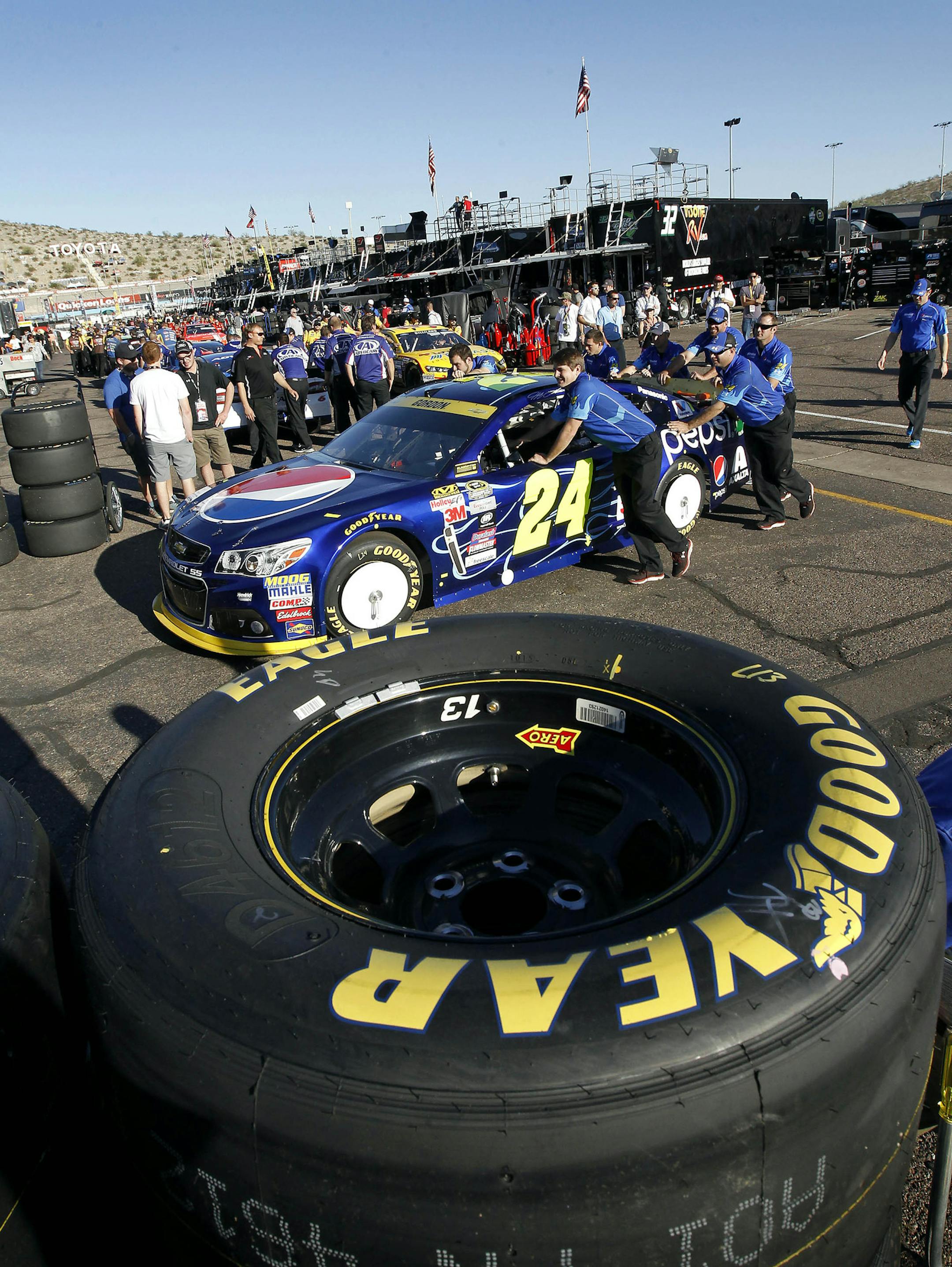 Pit crew members for Sprint Cup points leader Jeff Gordon push his Pepsi Chevrolet through inspection before qualifying for Sunday's NASCAR Sprint Cup auto race at Phoenix International Raceway, Friday, Nov. 13, 2015, in Avondale, Ariz. (AP Photo/Ralph Freso)