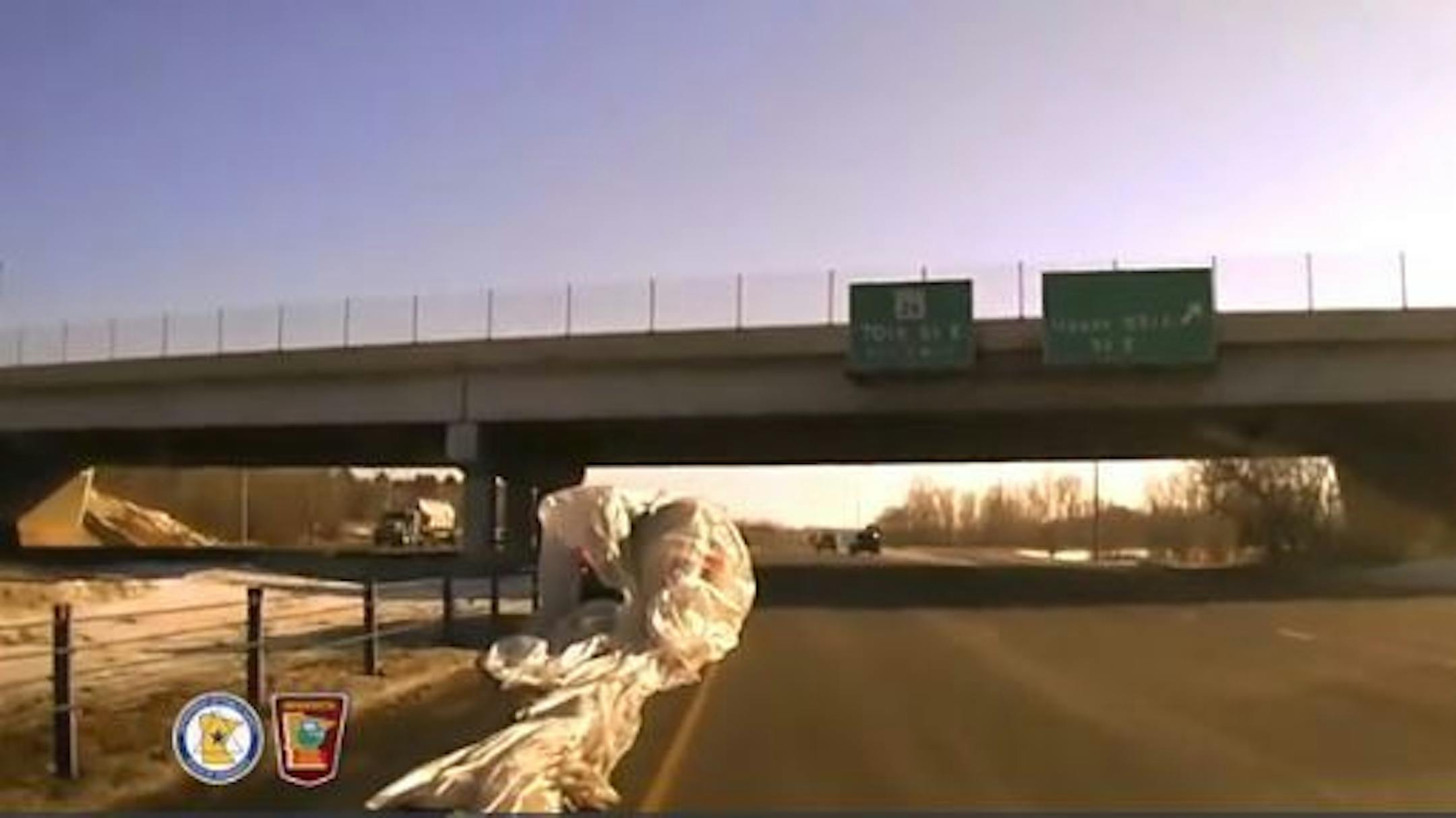 Screengrab from Minnesota State Patrol dashcam video shows an SUV smothered by a large plastic tarp that flew out of a dump truck on Hwy. 52.