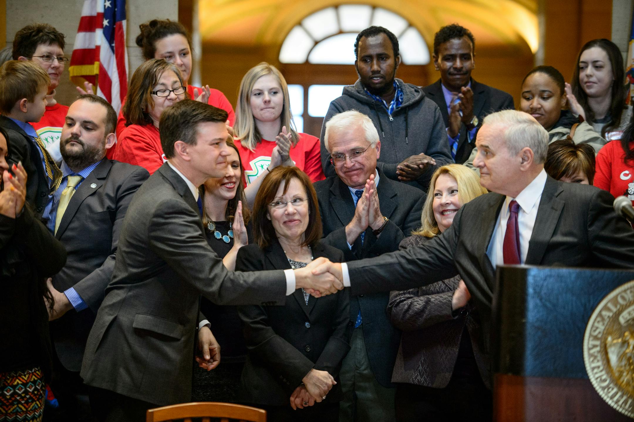 Gov. Mark Dayton shook hands with bill author Rep. Ryan Winkler, DFL-Golden Valley, after he signed the minimum wage bill into law at a public ceremony Monday in the Minnesota State Capitol Rotunda. April 14, 2014