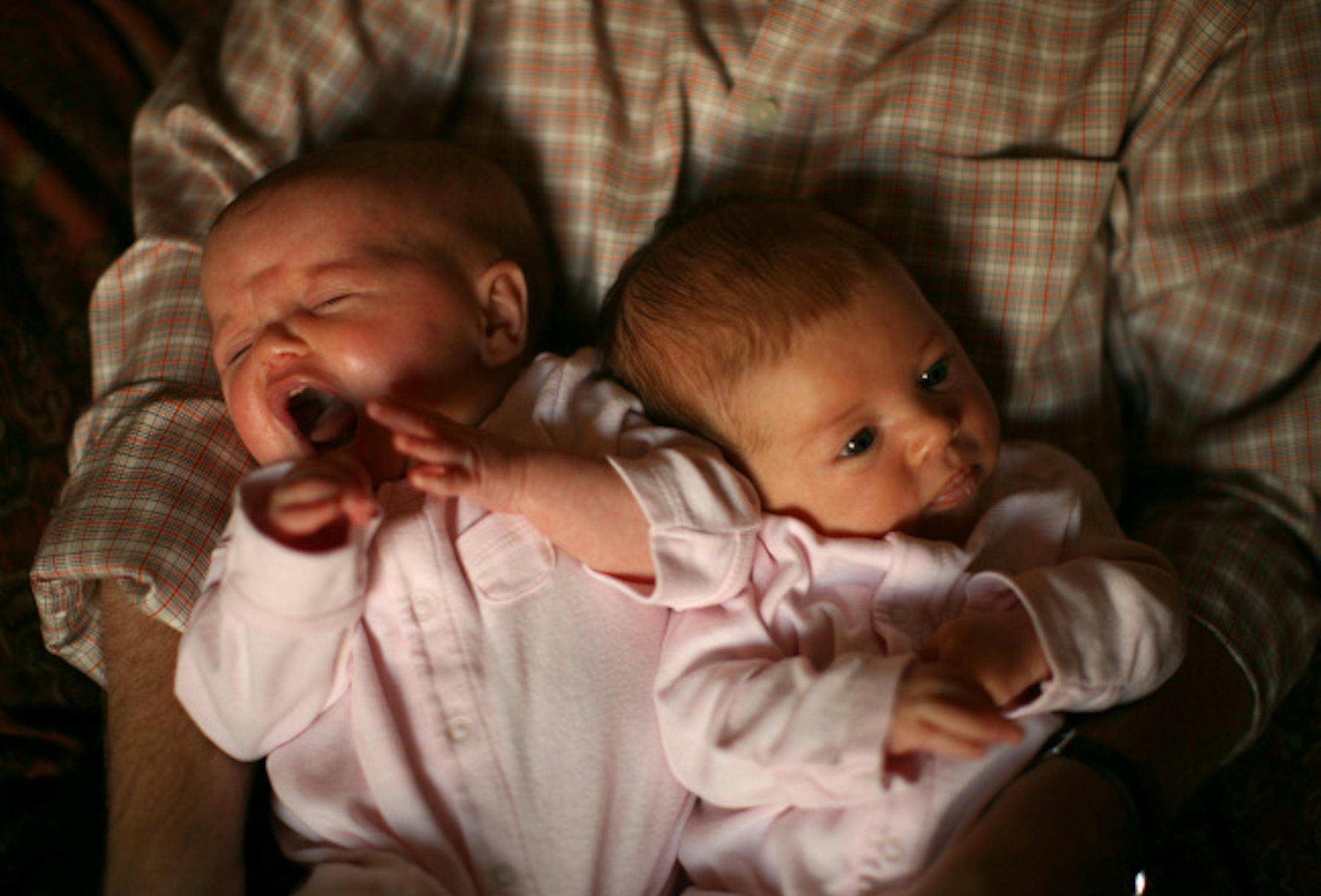 Two-month-old Elizabeth, left, and McKinney Caudill sat in their dad's lap Tuesday night. Jonathan and Ceresa Caudill were reluctant to freeze embryos if those not used in in-vitro fertilization might be destroyed. So they agreed to take part in the Mayo egg-freezing research.
