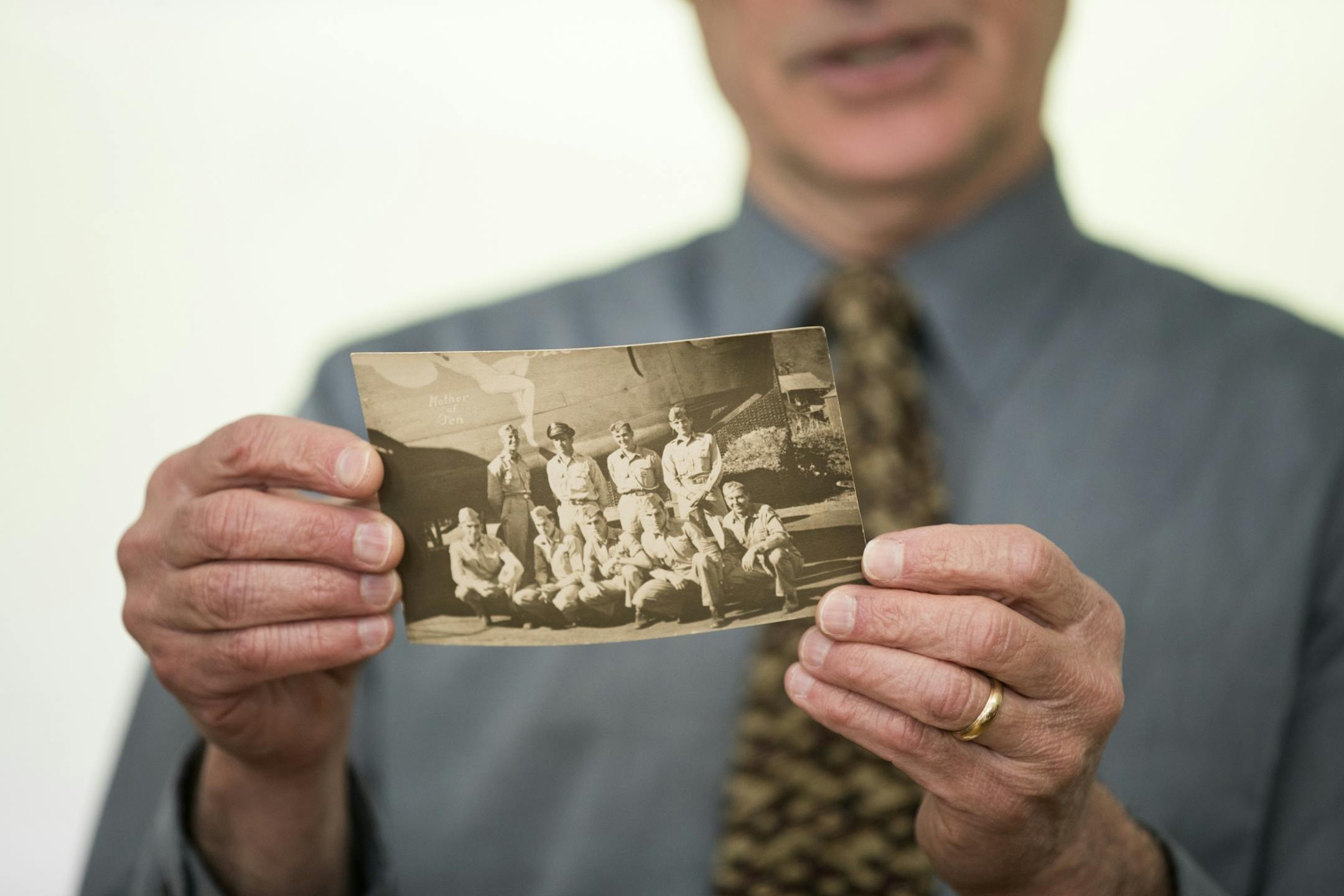 Dean Sheele holds the original photo of his father's WWII bomber crew.