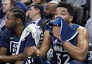 Minnesota Timberwolves' Andrew Wiggins (22) and Karl-Anthony Towns (32) watch from the bench in the final minute of the game against the Houston Rocke