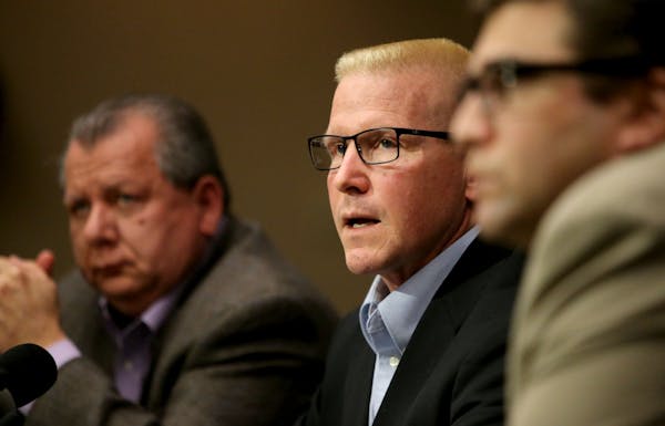 St. Paul Central High teacher John Ekblad, center, speaks to reporters last month at his attorneys' Bloomington office, recounting the injuries and wh