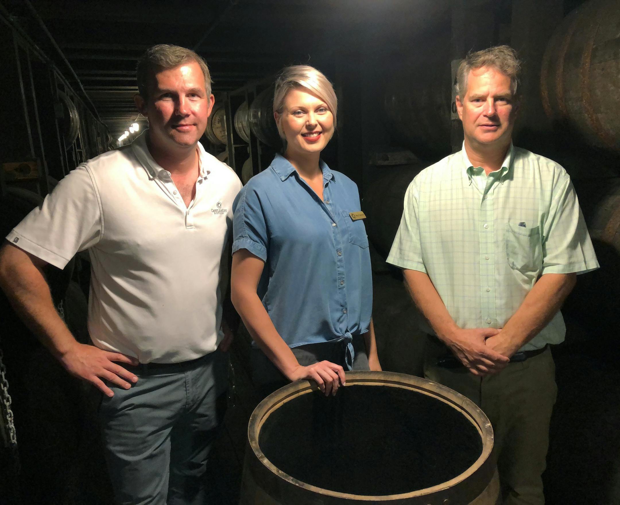 In this Friday, Sept. 14, 2018 photo, master distiller Marianne Eaves, center, is flanked by co-owners Will Arvin, right, and Wes Murray, while posing in a barrel warehouse Castle & Key Distillery in Millville, Ky. The group were behind the restoration of the Old Taylor distillery which is now known as Castle & Key Distillery. Eaves hopes rye can make its debut in about a year, and says the brandís bourbon could be ready in 2021. (AP Photo/Bruce Schreiner)