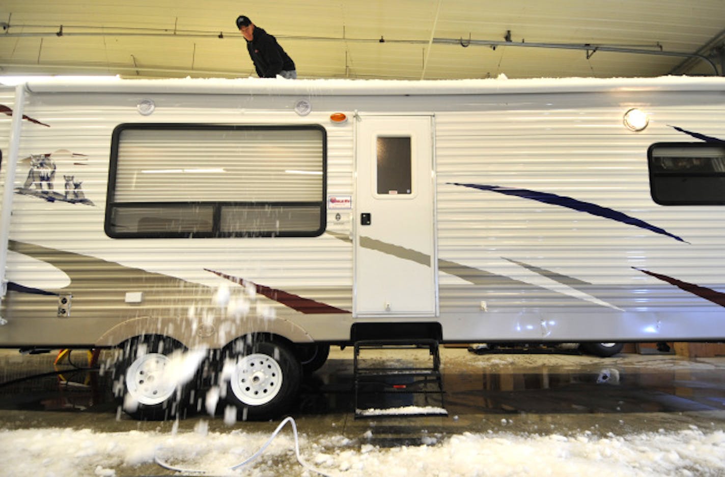 John Batchel worked Tuesday to prepare a 29-foot Puma travel trailer for Noble RV's third anniversary sale this weekend. Noble's sales have been rising even as the economy shivers and fuel costs soar. Partner Mike Noble said they're a less-expensive getaway than a second home by a lake.