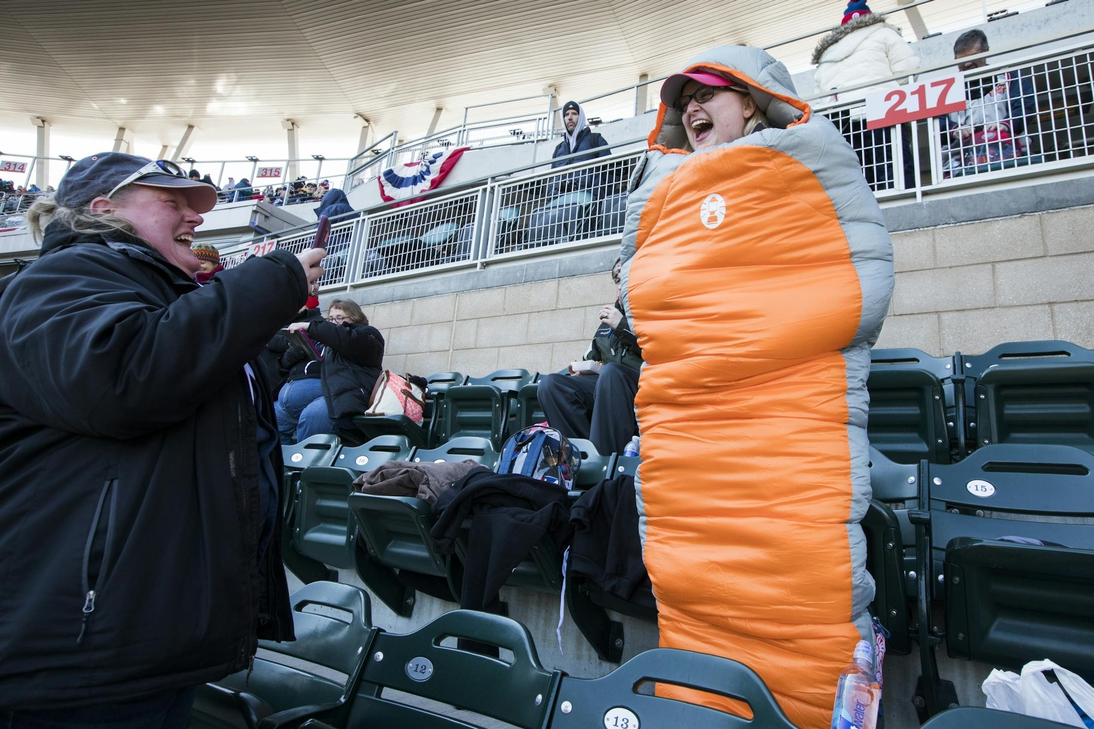 Brittany Workman, right, laughs as she poses for a photo by Beverly Warmka, both of Minneapolis, while wearing a sleeping bag she brought to stay warm before the game.