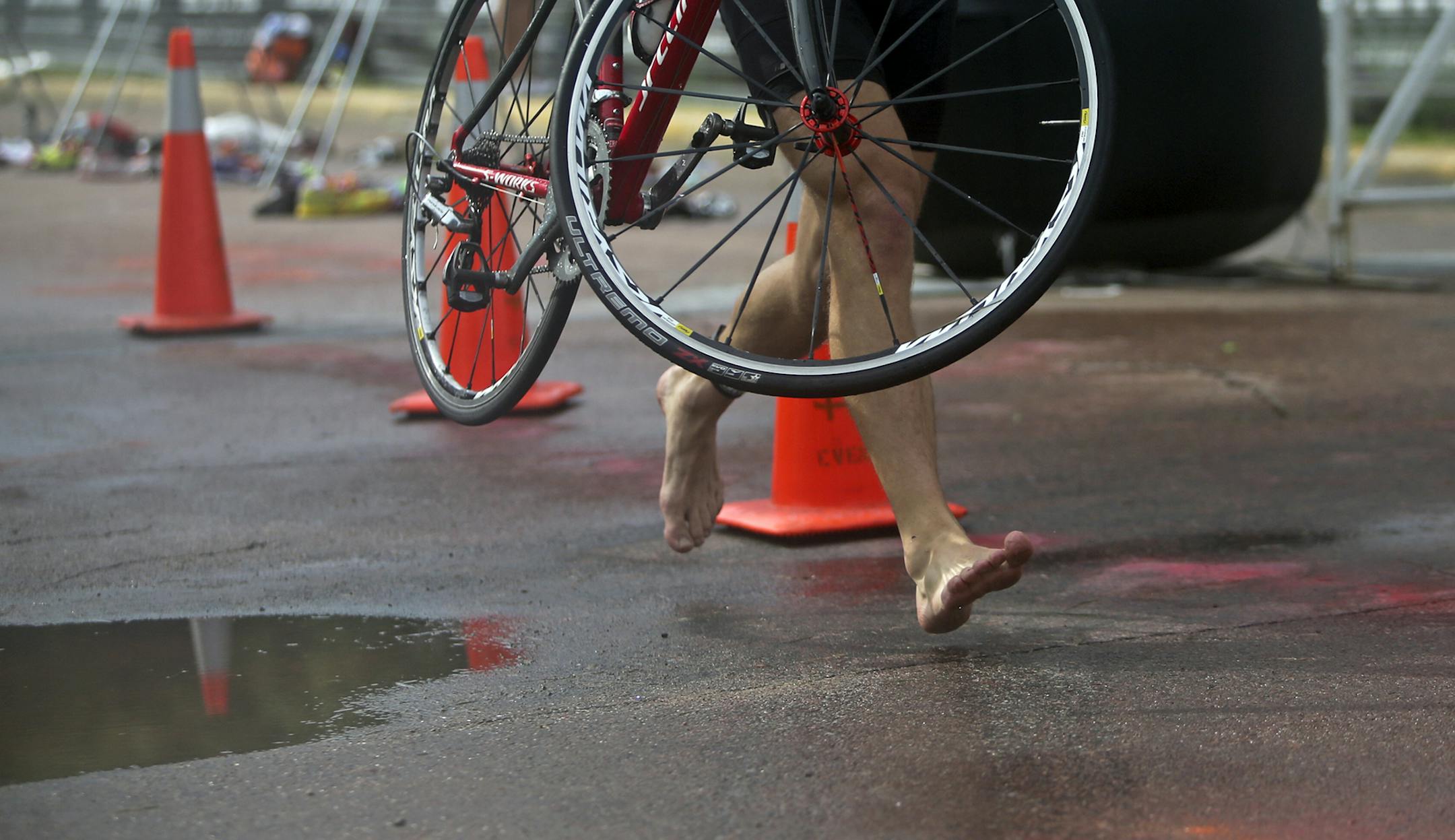 A barefooted triathlete having just finished swimming runs with his bike to the biking portion of the race during the Lifetime Fitness Triathlon Saturday, July 13, 2013, in Minneapolis, MN.](DAVID JOLES/STARTRIBUNE) djoles@startribune.com Lifetime Fitness Triathlon at Lake Nokomis Saturday, July 13, 2013, in Minneapolis, MN.