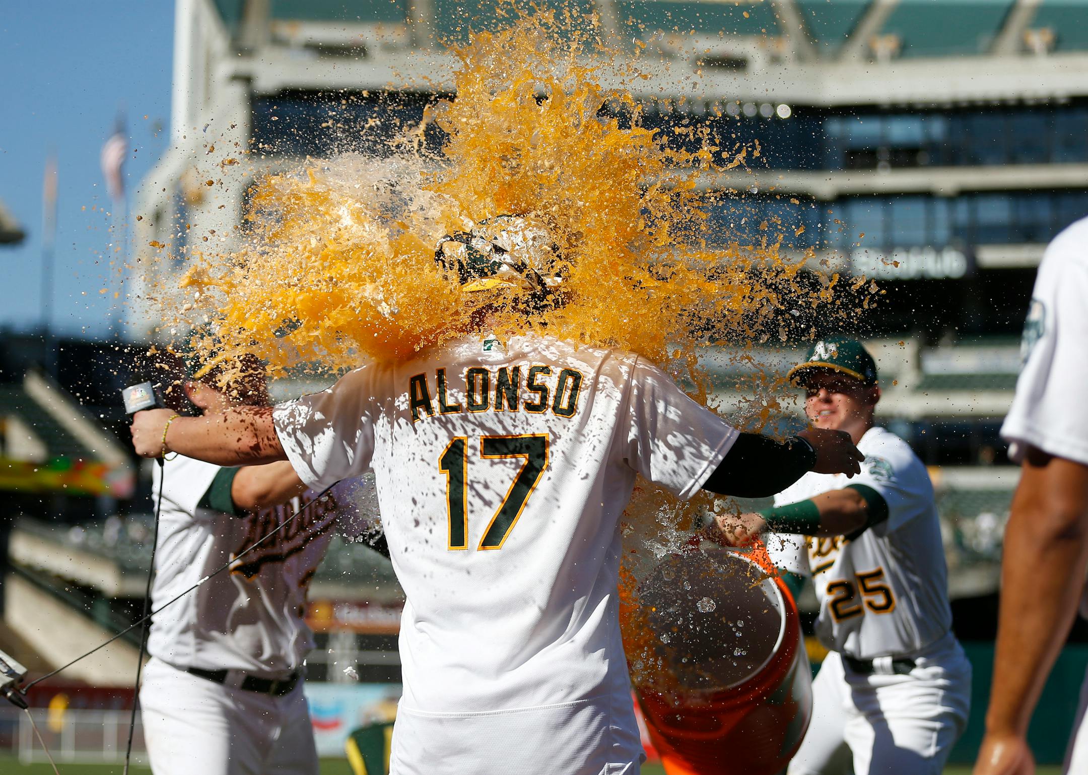 The Athletics' Yonder Alonso was splashed with Gatorade by Zach Neal, left, and Ryon Healy after he hit the game-winning home run against the Twins in the 12th inning to win the game 6-5 on Sunday.