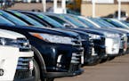A long row of unsold used Highlander sports-utility vehicles sits at a Toyota dealership in Englewood, Colo.
