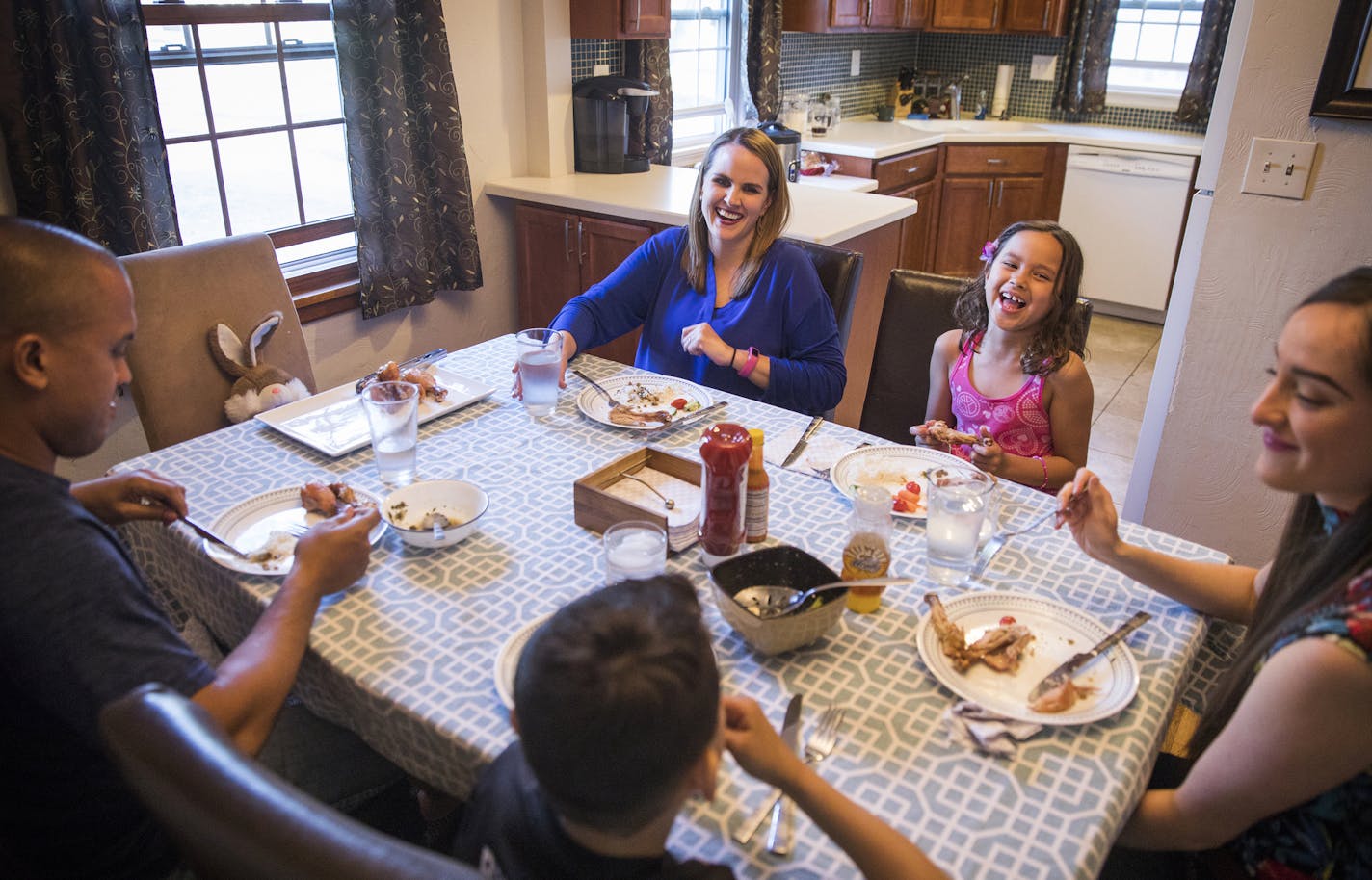 The Chung family laughs together during dinner. Clockwise from bottom is José, 9, father Octavio, mother Mary, Elena, 7, and Kiara Orozco, an exchange teacher from Colombia.