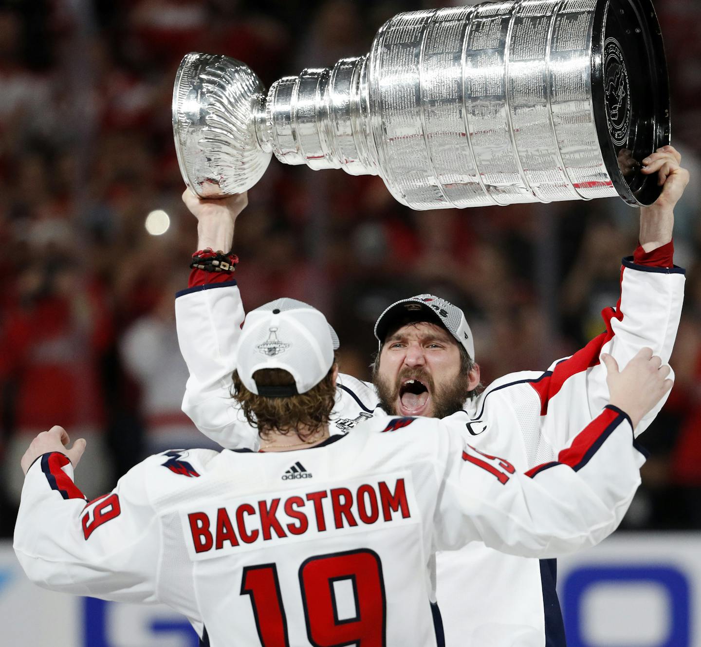 Washington Capitals left wing Alex Ovechkin, of Russia, hands the Stanley Cup to center Nicklas Backstrom, of Sweden, after the Capitals defeated the Golden Knights 4-3 in Game 5 of the NHL hockey Stanley Cup Finals Thursday, June 7, 2018, in Las Vegas. (AP Photo/John Locher)