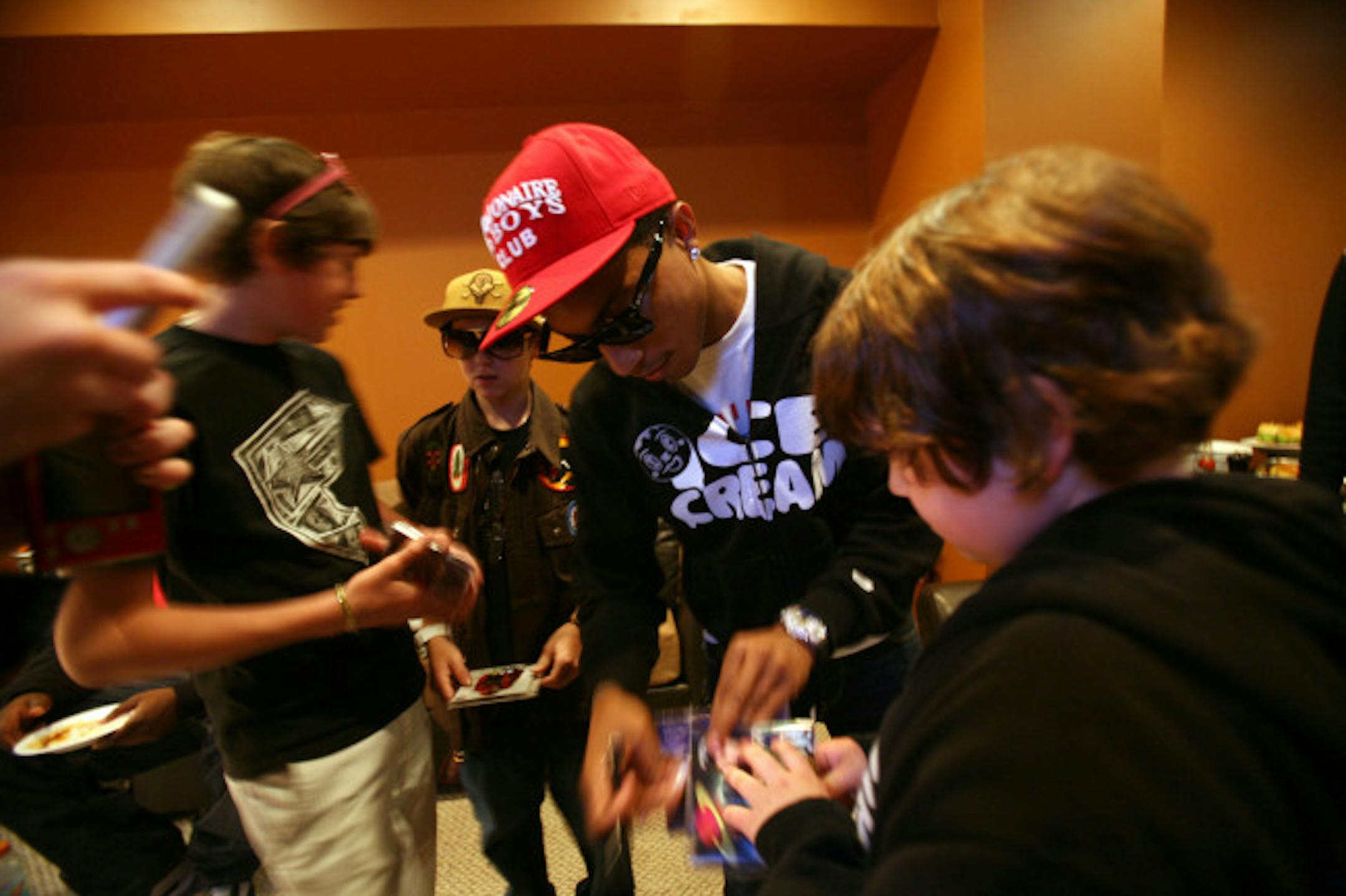 Pharrell Williams autographed cds for fans at Status, an upscale hip hop shoes and clothing store in Uptown.