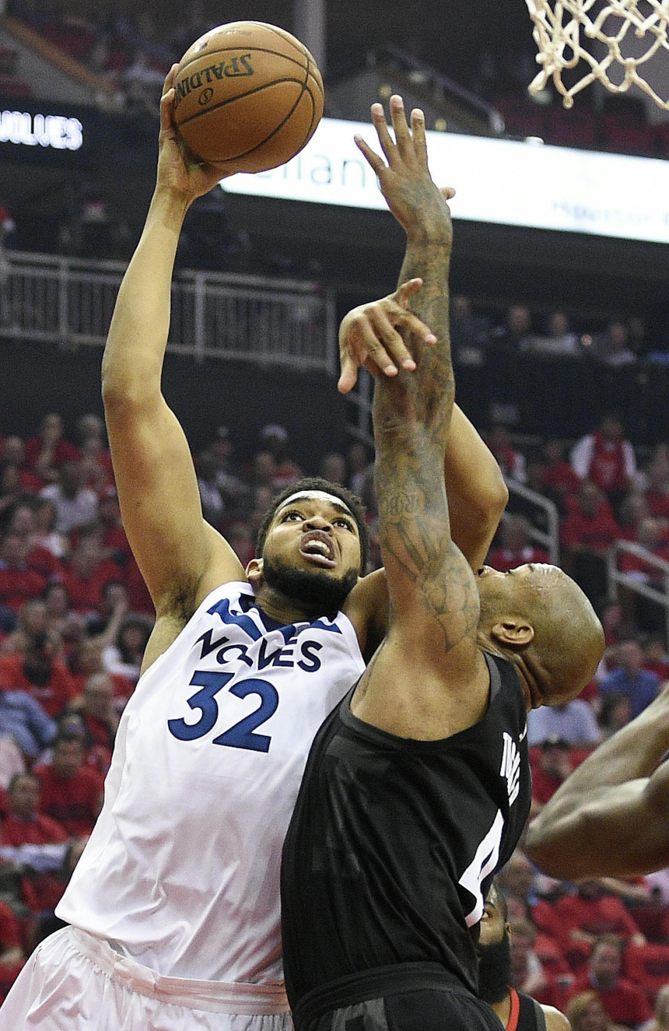 Minnesota Timberwolves center Karl-Anthony Towns (32) shoots as Houston Rockets forward PJ Tucker defends during the first half in Game 5 of a first-round NBA basketball playoff series, Wednesday, April 25, 2018, in Houston.