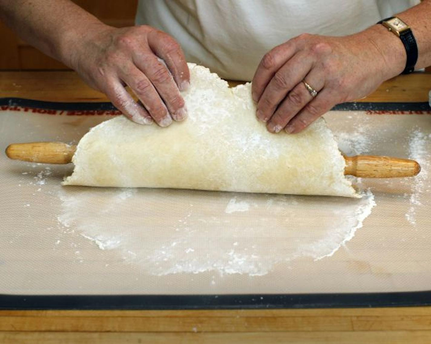 Drape the rolled dough over the rolling pin to transfer it to the baking sheet.