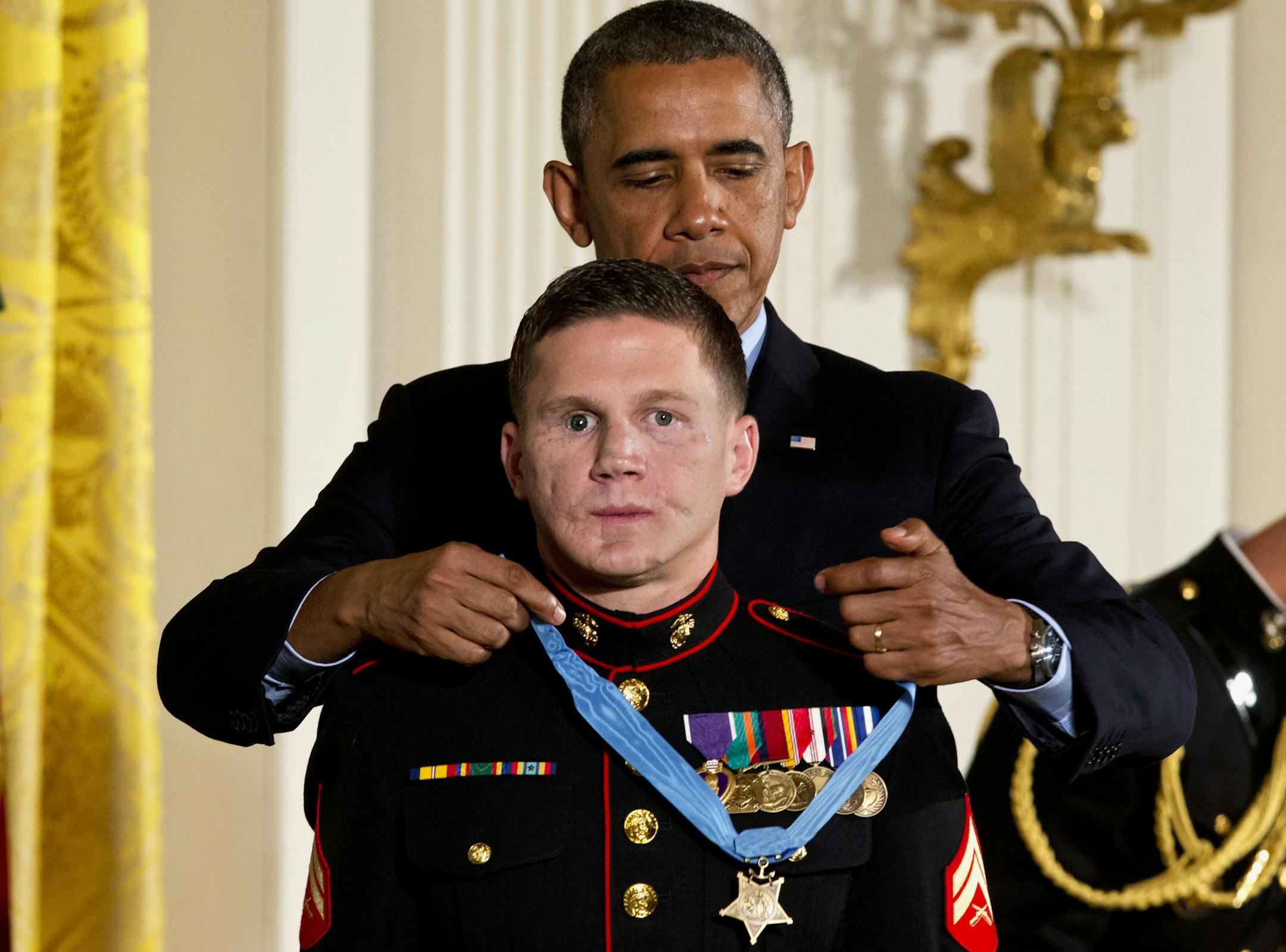 President Barack Obama awards retired Marine Cpl. William "Kyle" Carpenter, the Medal of Honor for conspicuous gallantry, Thursday, June 19, 2014, during a ceremony in the East Room of the White House in Washington. Carpenter received the Medal of Honor for his courageous actions while serving as an Automatic Rifleman in Helmand Province, Afghanistan. (AP Photo/Jacquelyn Martin)