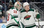 Minnesota Wild goaltender Cam Talbot (33) greets center Rem Pitlick, right, after the Wild defeated the Seattle Kraken 4-2 in an NHL hockey game, Satu