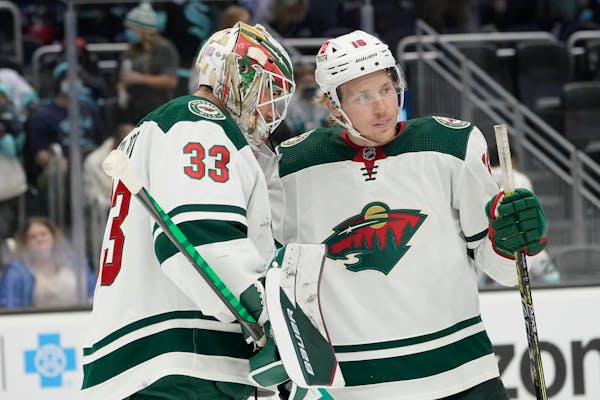 Minnesota Wild goaltender Cam Talbot (33) greets center Rem Pitlick, right, after the Wild defeated the Seattle Kraken 4-2 in an NHL hockey game, Satu
