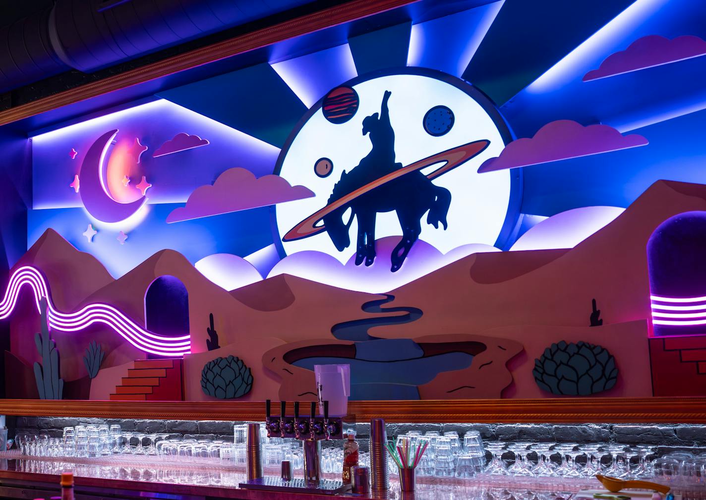 Behind the bar at Fool Me Once in Minneapolis' Uptown is a changing neon light installation depicting a cowboy.