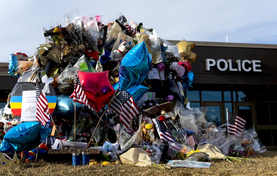 Flowers, balloons, notes, and other items were placed on a police vehicle outside of the Burnsville police department on Monday.