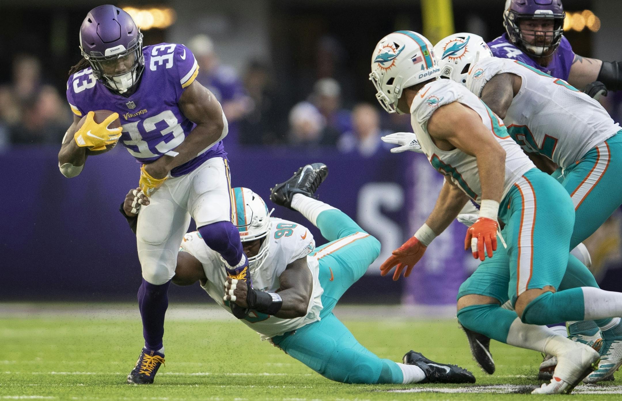 Minnesota Vikings running back Dalvin Cook (33) breaks the tackle of Miami Dolphins defensive end Charles Harris (90) for first down in the forth quarter at U.S. Bank Stadium Sunday December 16, 2018 in Minneapolis, MN.