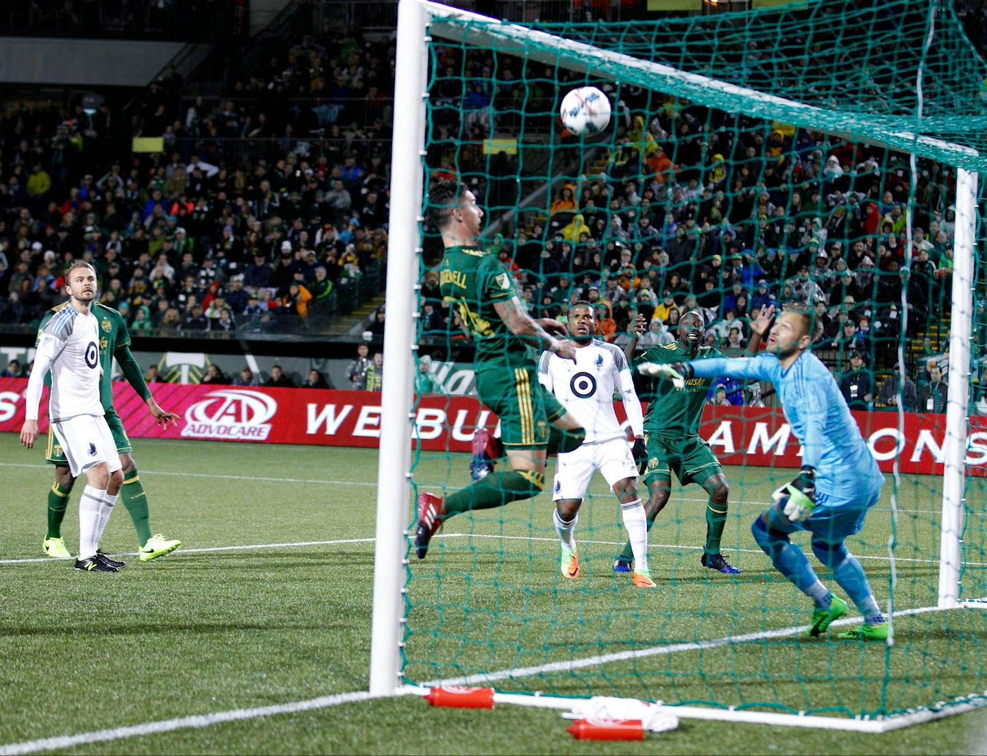 Portland Timbers' Lawrence Olum (13) watches in the background as his shot soars above teammate Liam Ridgewell (24) and into the net for Portland's first goal against Minnesota United