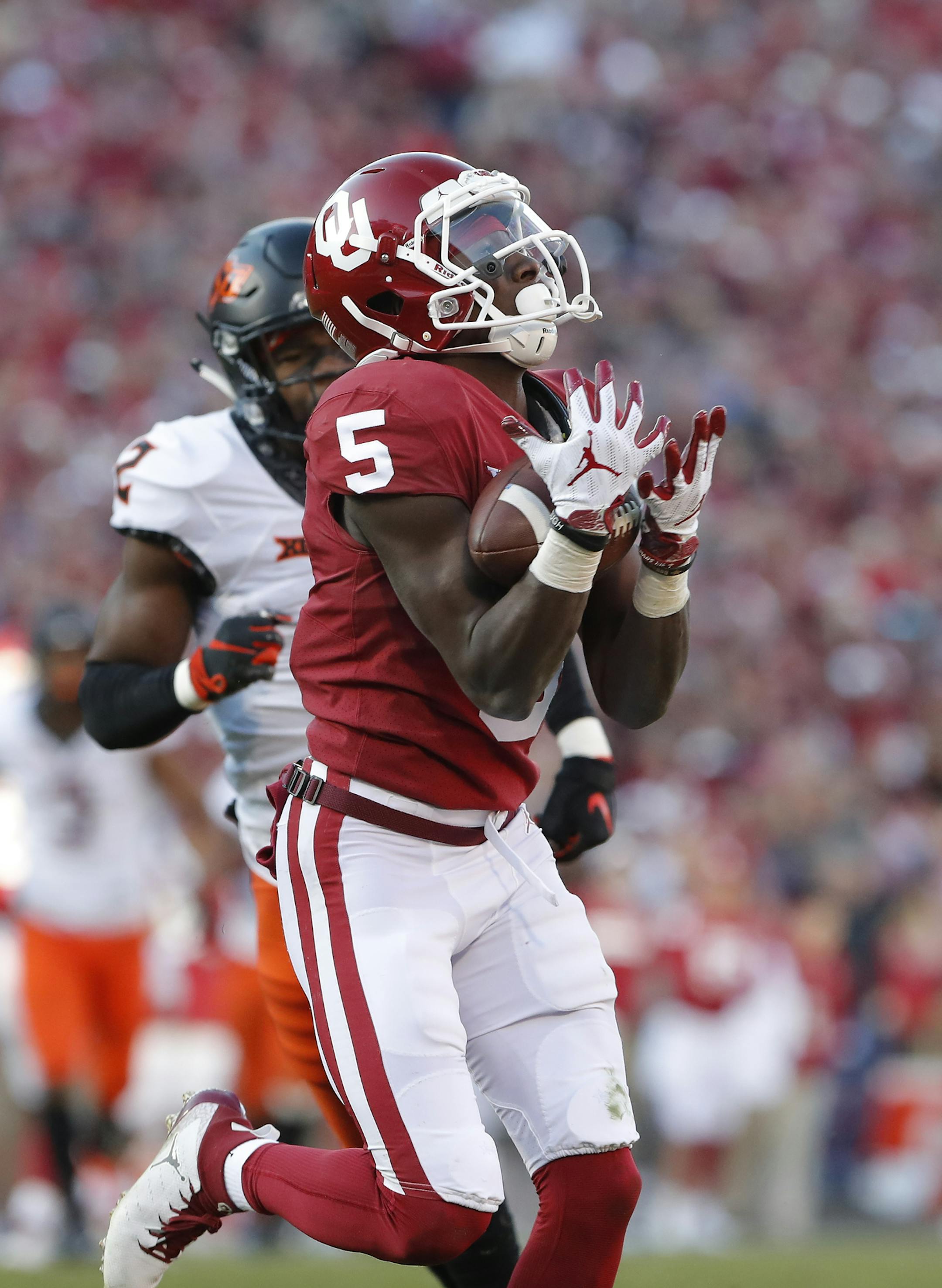Oklahoma wide receiver Marquise Brown (5) makes a catch ahead of Oklahoma State cornerback Tanner McCalister (2) in the second quarter of an NCAA college football game in Norman, Okla., Saturday, Nov. 10, 2018. (AP Photo/Alonzo Adams)