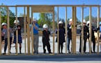 Shena Idoko (center, blue dress) worked with a Habitat for Humanity construction crew of volunteers and professionals this month to erect a wall of Id