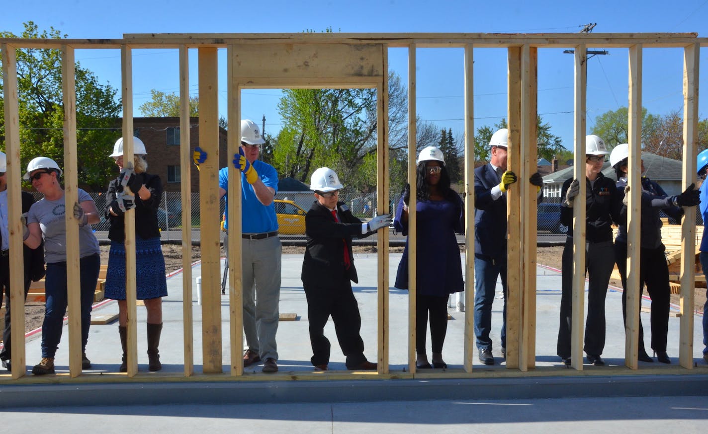 Shena Idoko (center, blue dress) worked with a Habitat for Humanity construction crew of volunteers and professionals this month to erect a wall of Idoko's under-construction home in St. Paul's North End neigbhorhood. Habitat, fueled partly by a mortgage program underwritten by Bremer Bank, expects to put a record 110 working-class families into Twin Cities homes this year through new-construction and existing-home rehab-and-loan programs. Photo: Habitat for Humanity