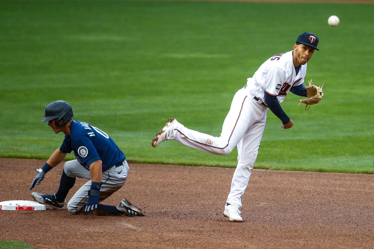 Minnesota Twins shortstop Andrelton Simmons forces out Seattle Mariners' Sam Haggerty and turns a double play on a ball hit by J.P. Crawford in the seventh inning of a baseball game Thursday, April 8, 2021, in Minneapolis. The Twins won 10-2. (AP Photo/Bruce Kluckhohn)