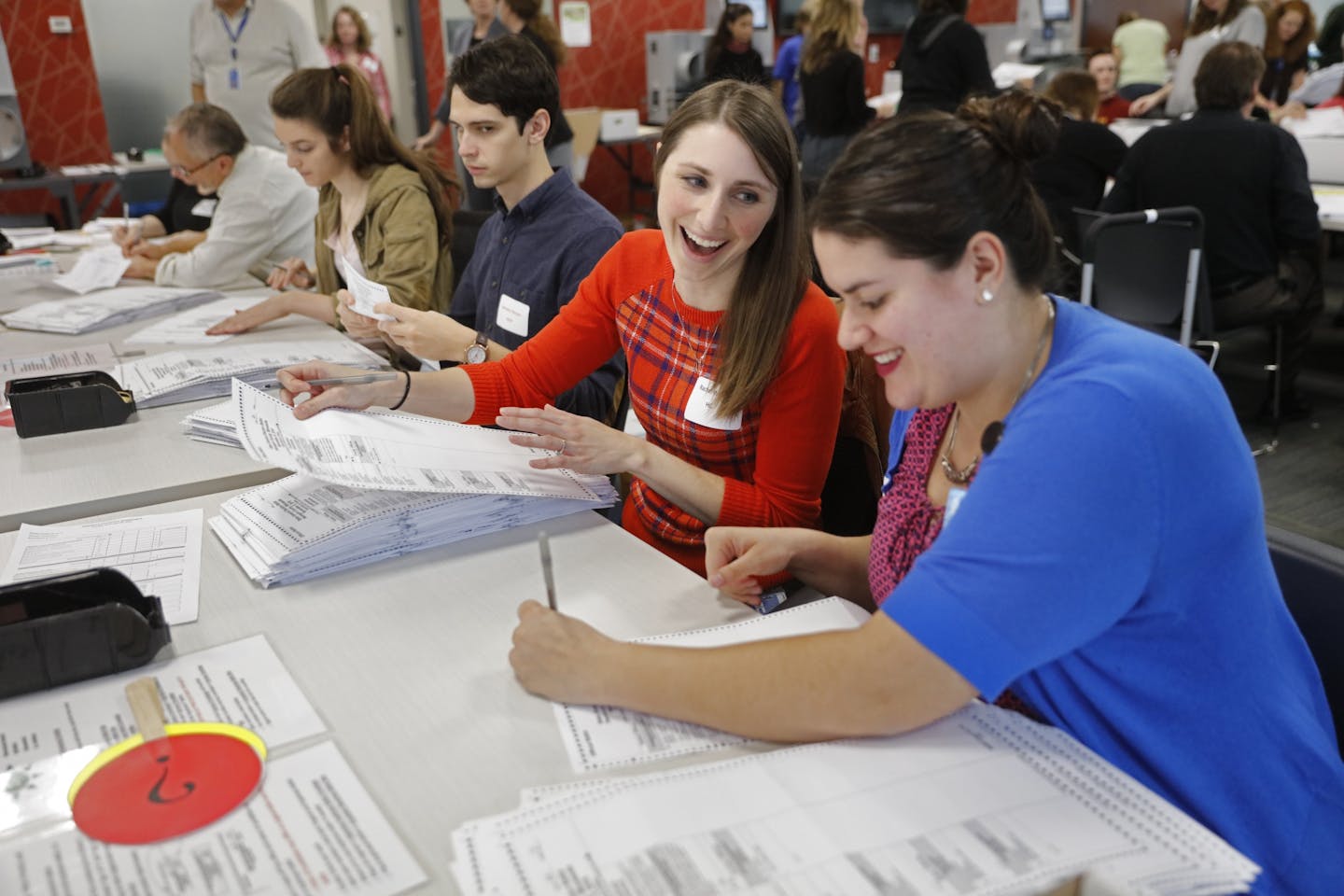 Hundreds of volunteers and election officials started the absentee ballot count this week for all of the Hennepin County cities, except Minneapolis, in downtown Minneapolis. Left, Rachel Walch and, right, Erin Lewis worked together to verify ballots and prepared them to be counted.