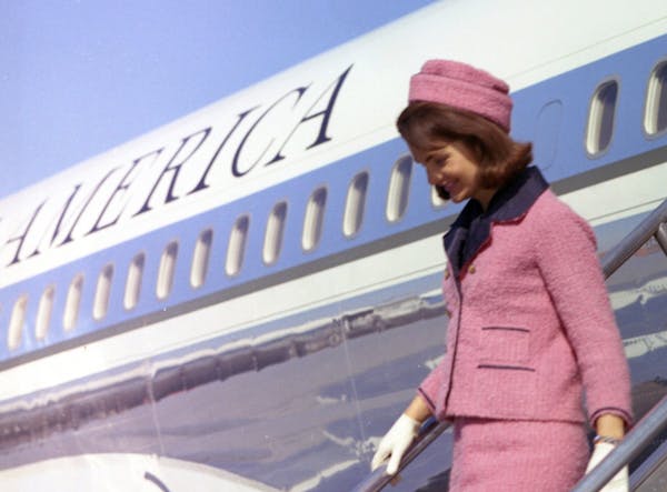 Dressed in her iconic pink suit, First Lady Jacqueline Kennedy arrives in Dallas on Nov. 22, 1963.