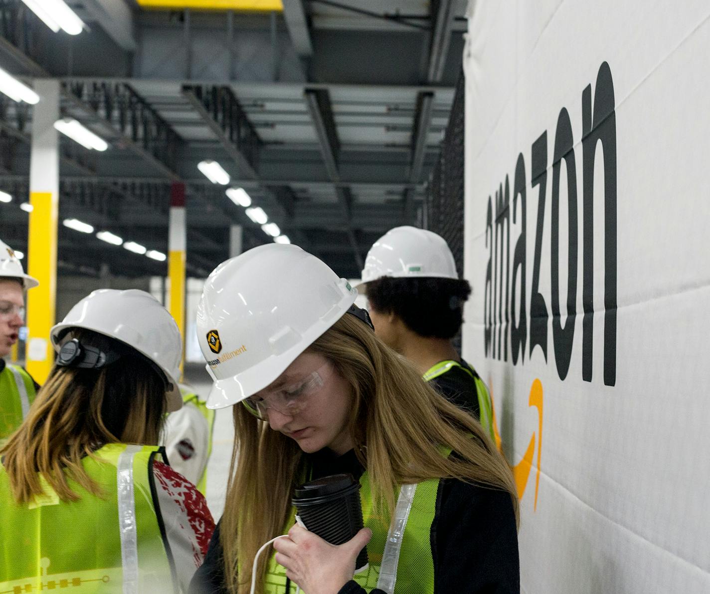 Members of Shakopee Robotics, the Shakopee Senior High School's Robotoic Team, pick up gift bags after displaying their personally designed robots in the not yet open Amazon Shakopee fulfillment center Friday morning. Amazon awarded the robotics team 10,000 dollars. ] Elizabeth Brumley special to the Star Tribune