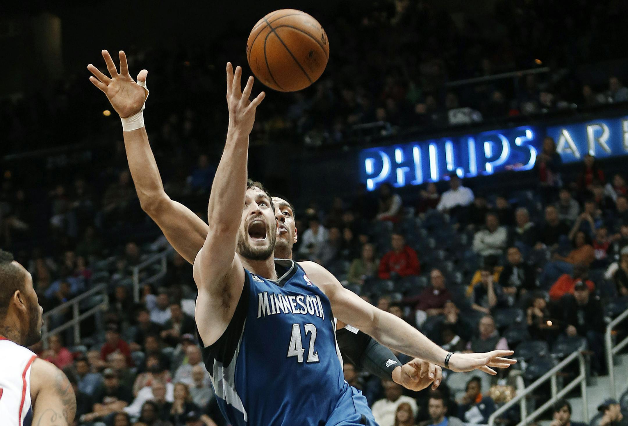 Minnesota Timberwolves forward Kevin Love (42) scores against Atlanta Hawks forward Gustavo Ayon, obscured, during the second half of an NBA basketball game Saturday, Feb. 1, 2014, in Atlanta. Atlanta won 120-113. (AP Photo/John Bazemore)