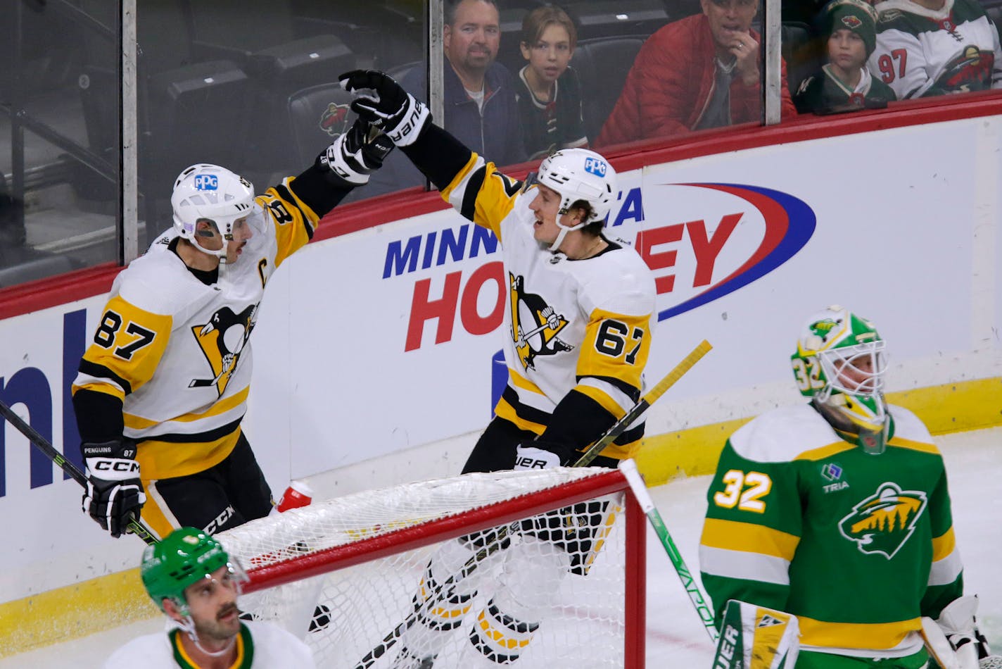 Penguins center Sidney Crosby (87) celebrates with right wing Rickard Rakell after scoring a goal against Wild goaltender Filip Gustavsson during the first period Thursday.