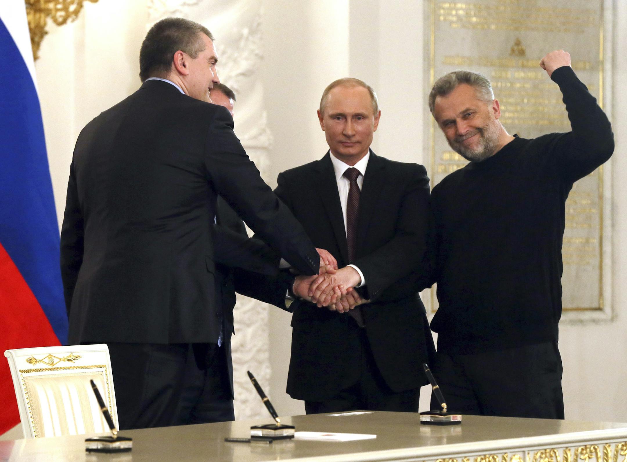 Russian President Vladimir Putin, second from right, with Crimean leaders after signing a draft treaty to make the strategic Black Sea peninsula part of Russia at the Kremlin in Moscow, March 18, 2014. Putin claimed Crimea as a part of Russia Tuesday, brushing aside international condemnation that could leave Russia deeply isolated for years to come. From left: Sergei Aksyonov, the newly declared prime minister of Crimea, Putin, and Sevastopol Mayor Alexei Chaliy. (Sergei Ilnitsky/Pool via The N